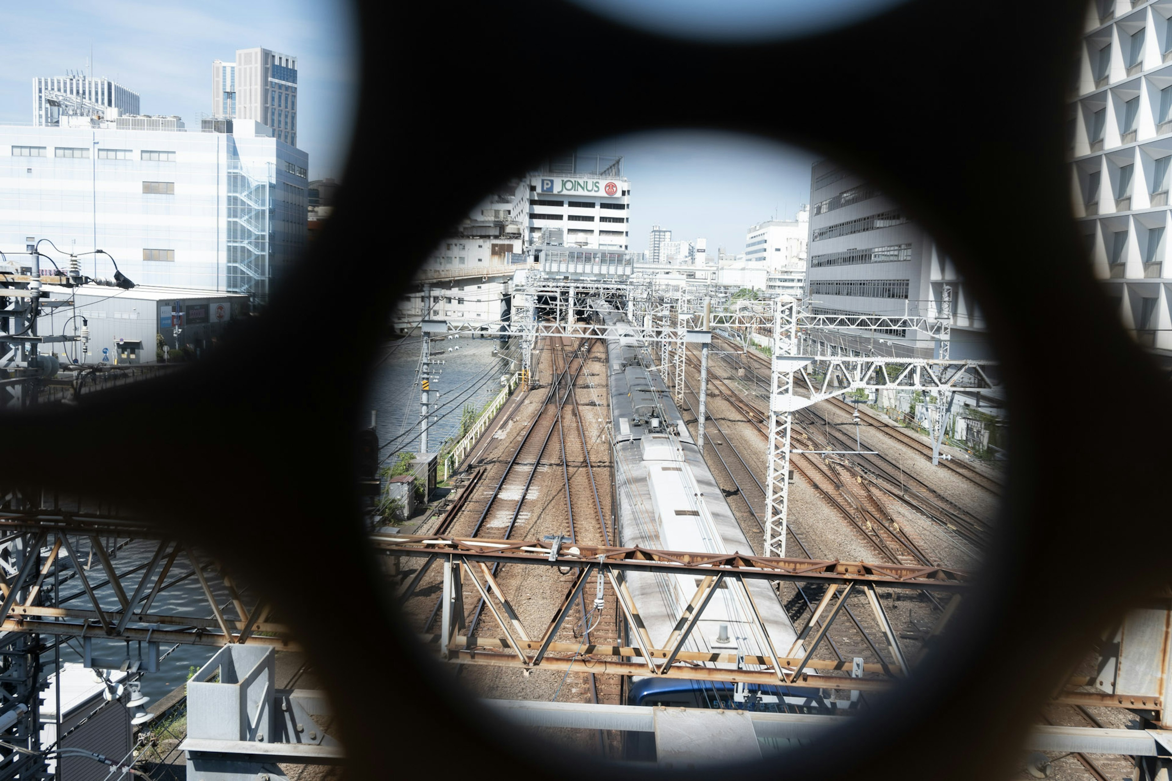 透過圓形開口看到的鐵路軌道的城市風景