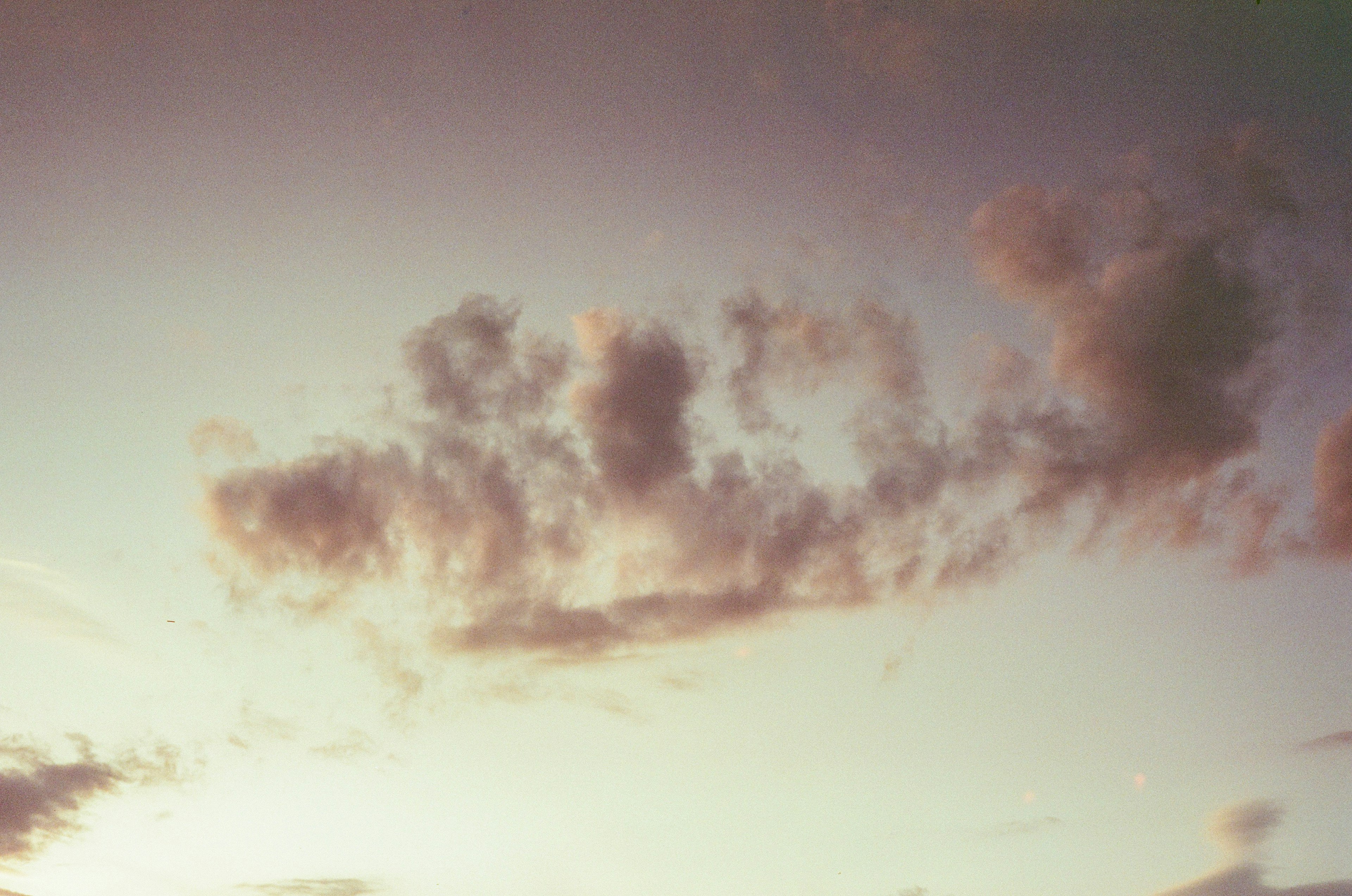 Sanfte Wolken, die in einem Sonnenuntergangshimmel treiben