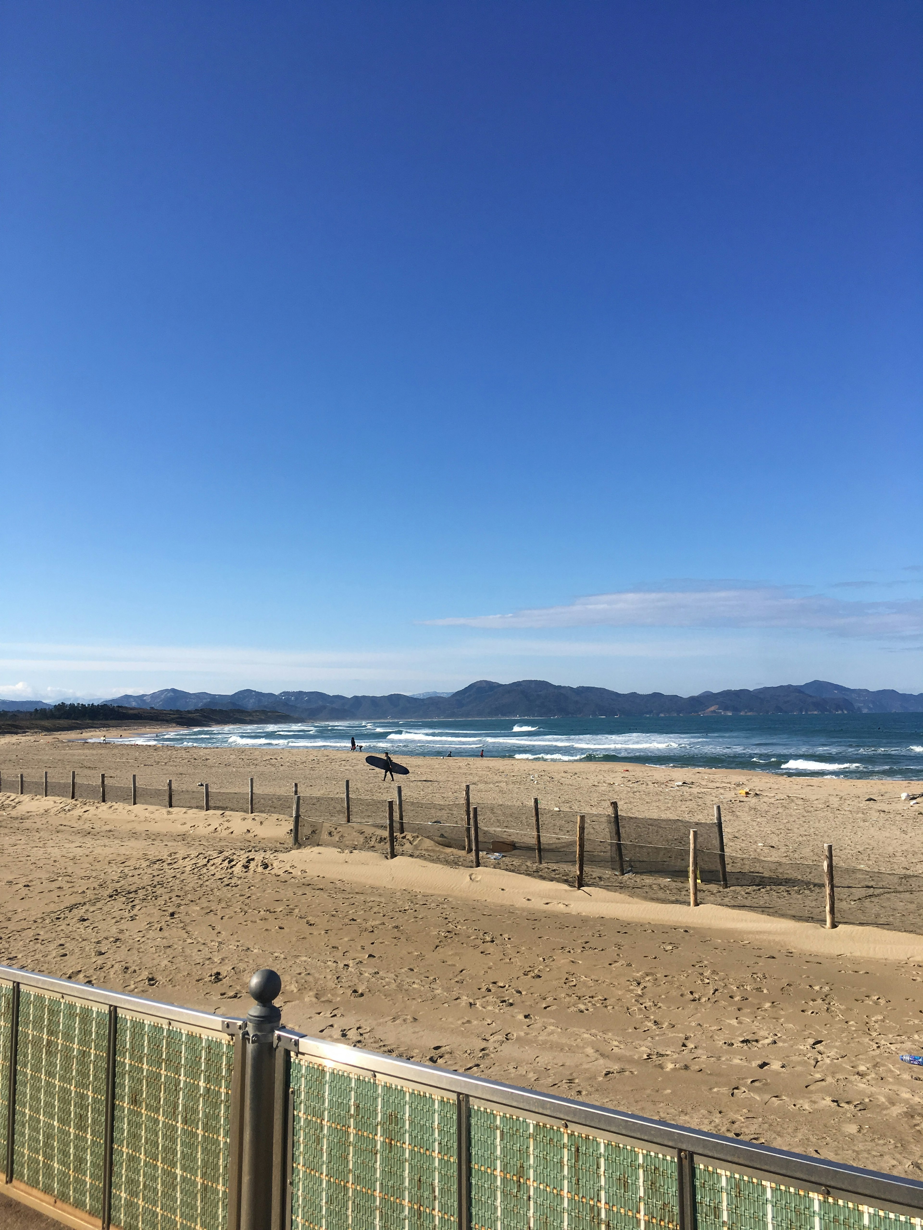 Vista panoramica della spiaggia con cielo azzurro e onde leggere