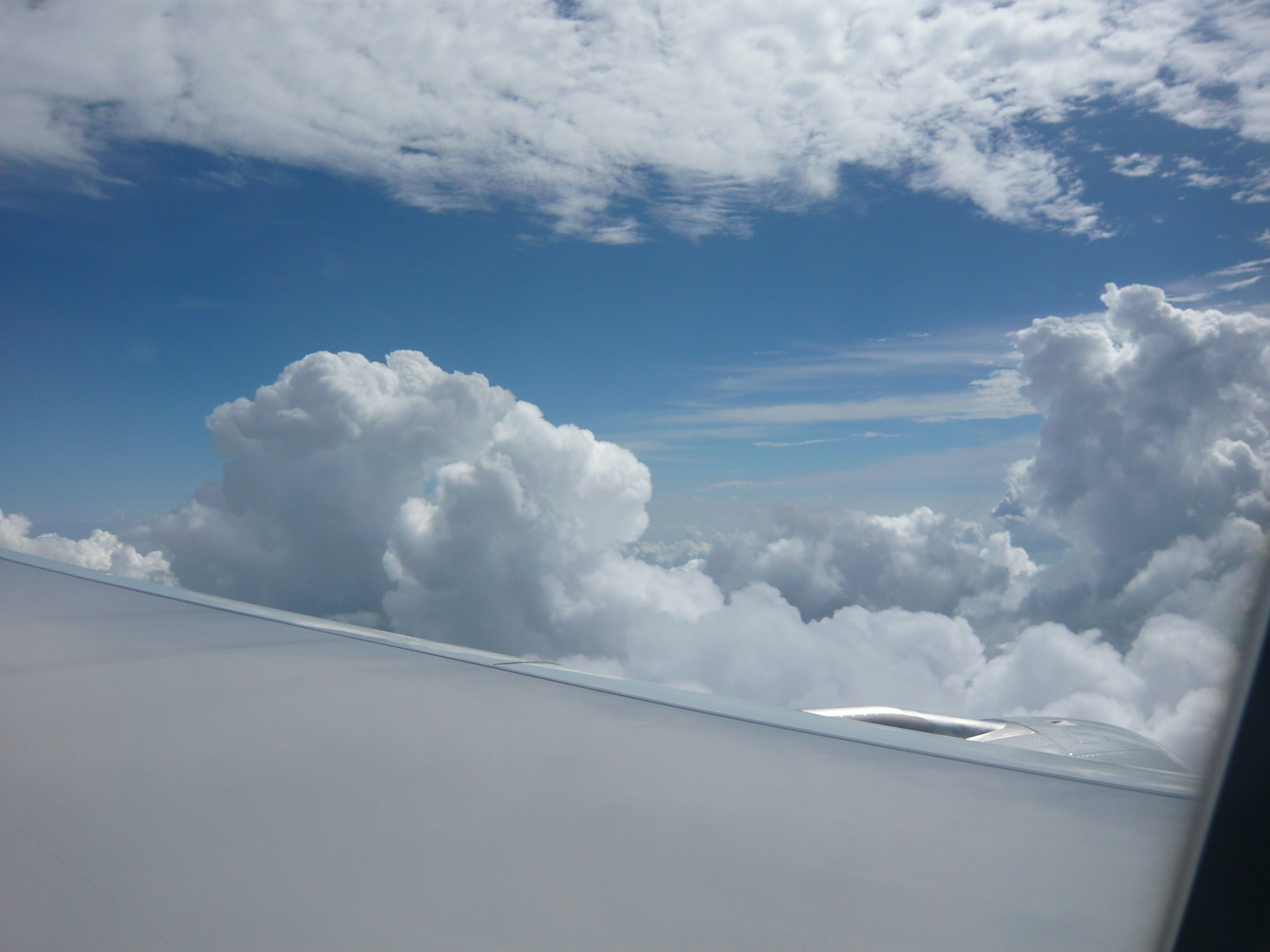 Pemandangan langit biru dan awan putih dari sayap pesawat