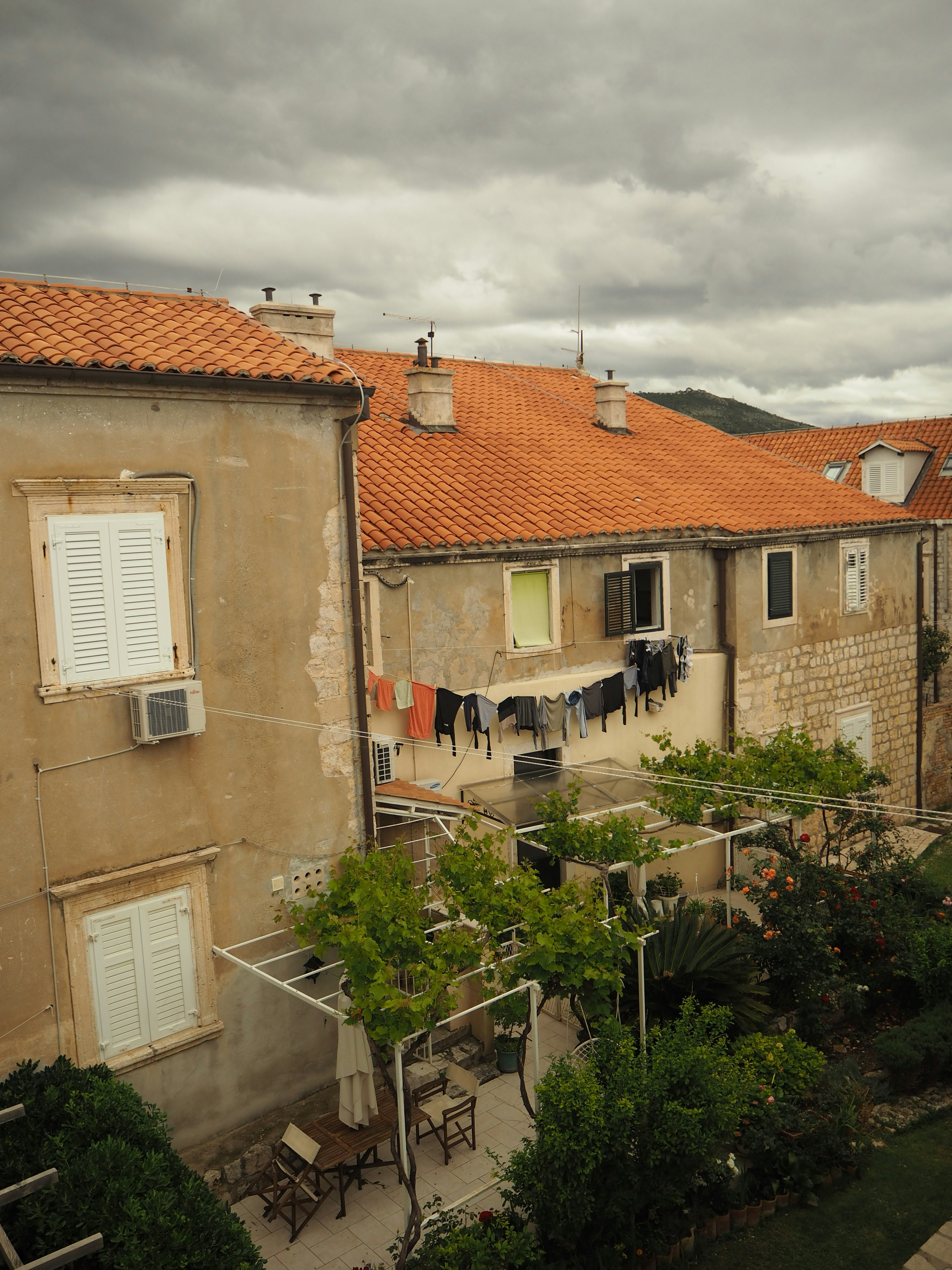 Vue de bâtiments avec des toits rouges et du linge suspendu dans une cour