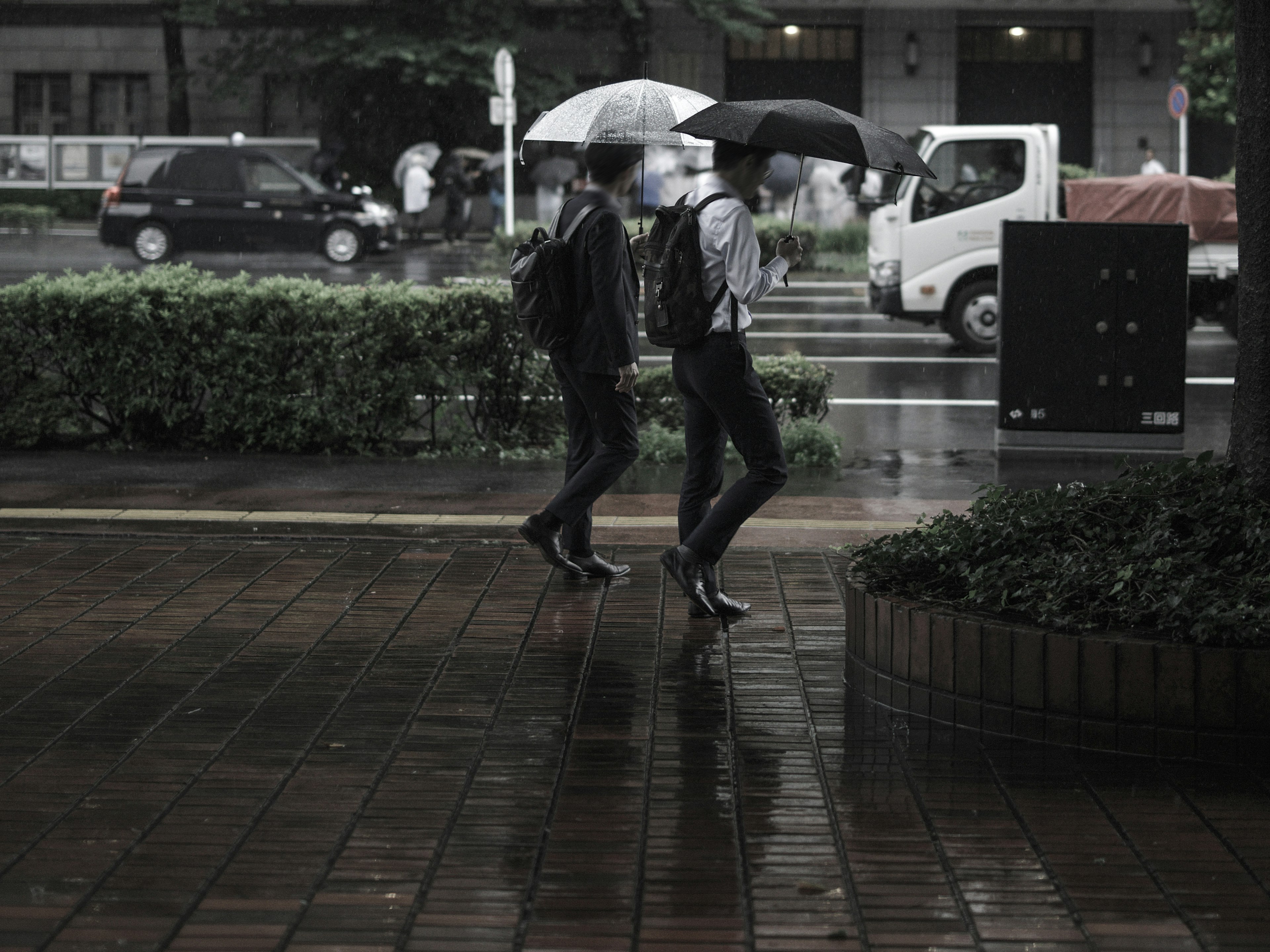 Dos personas caminando con paraguas bajo la lluvia