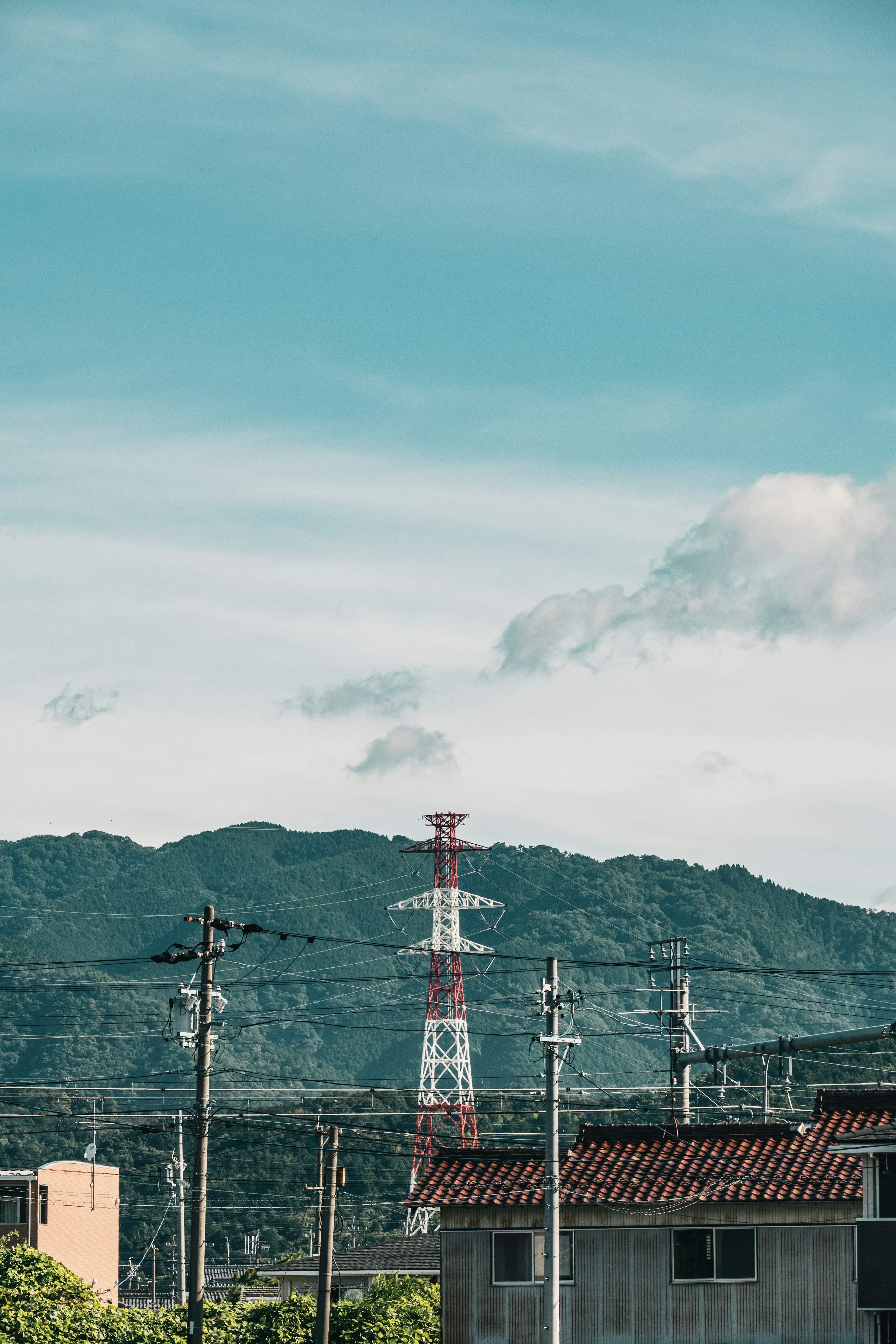 青い空の下に山と通信塔が見える風景