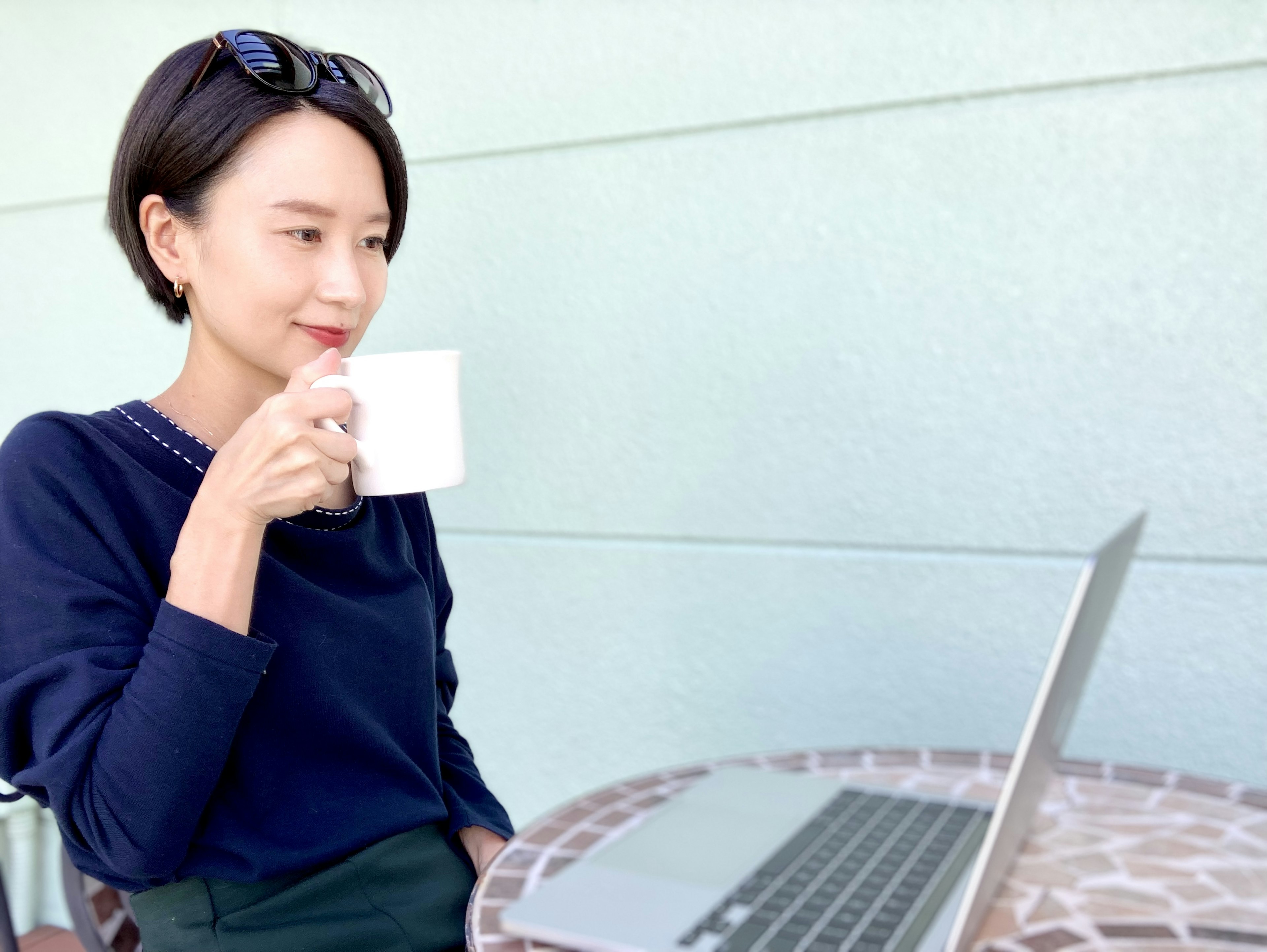 Frau trinkt Kaffee während sie in einem Café einen Laptop benutzt