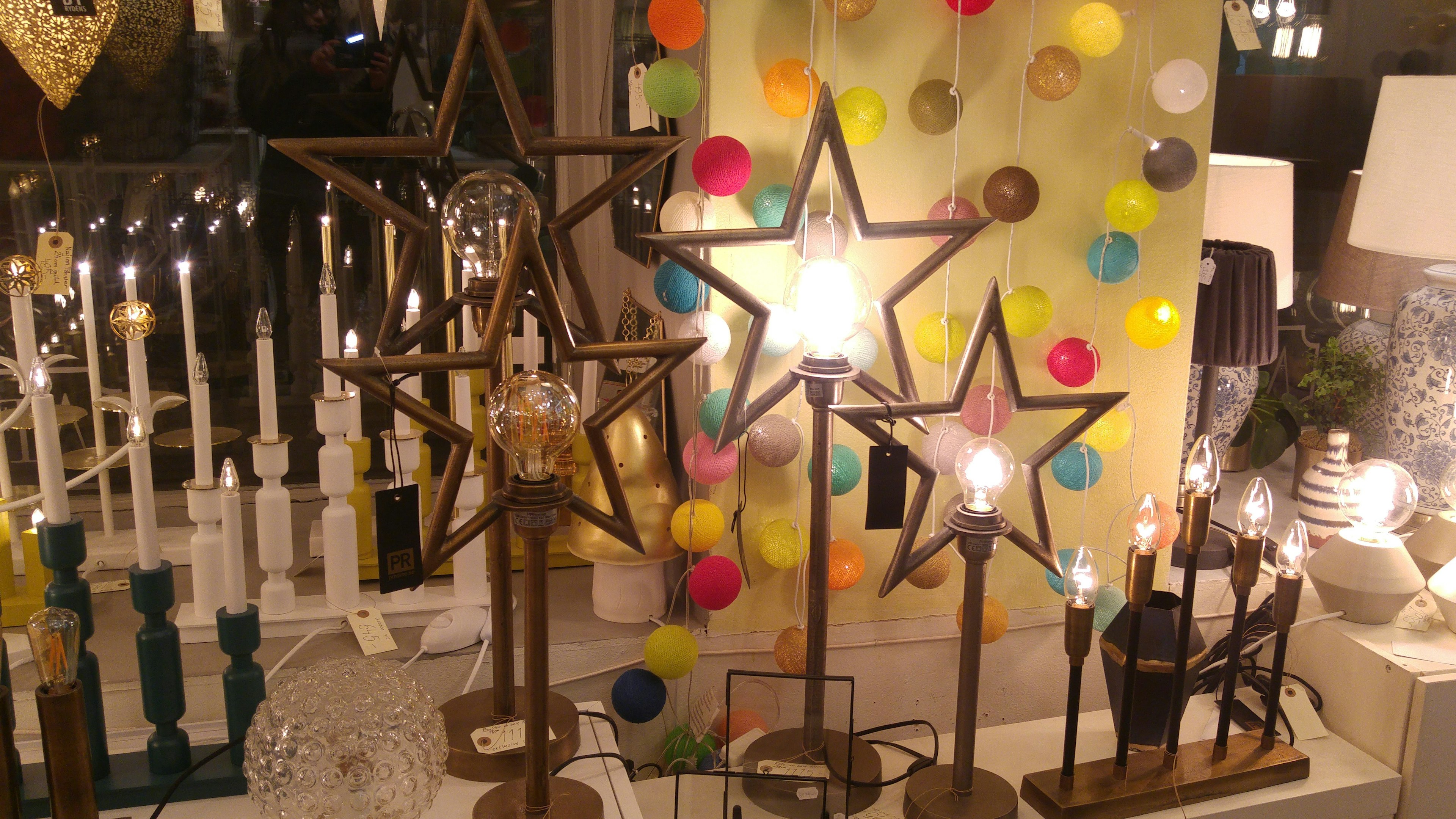 Exhibición decorativa con lámparas en forma de estrella y decoraciones coloridas