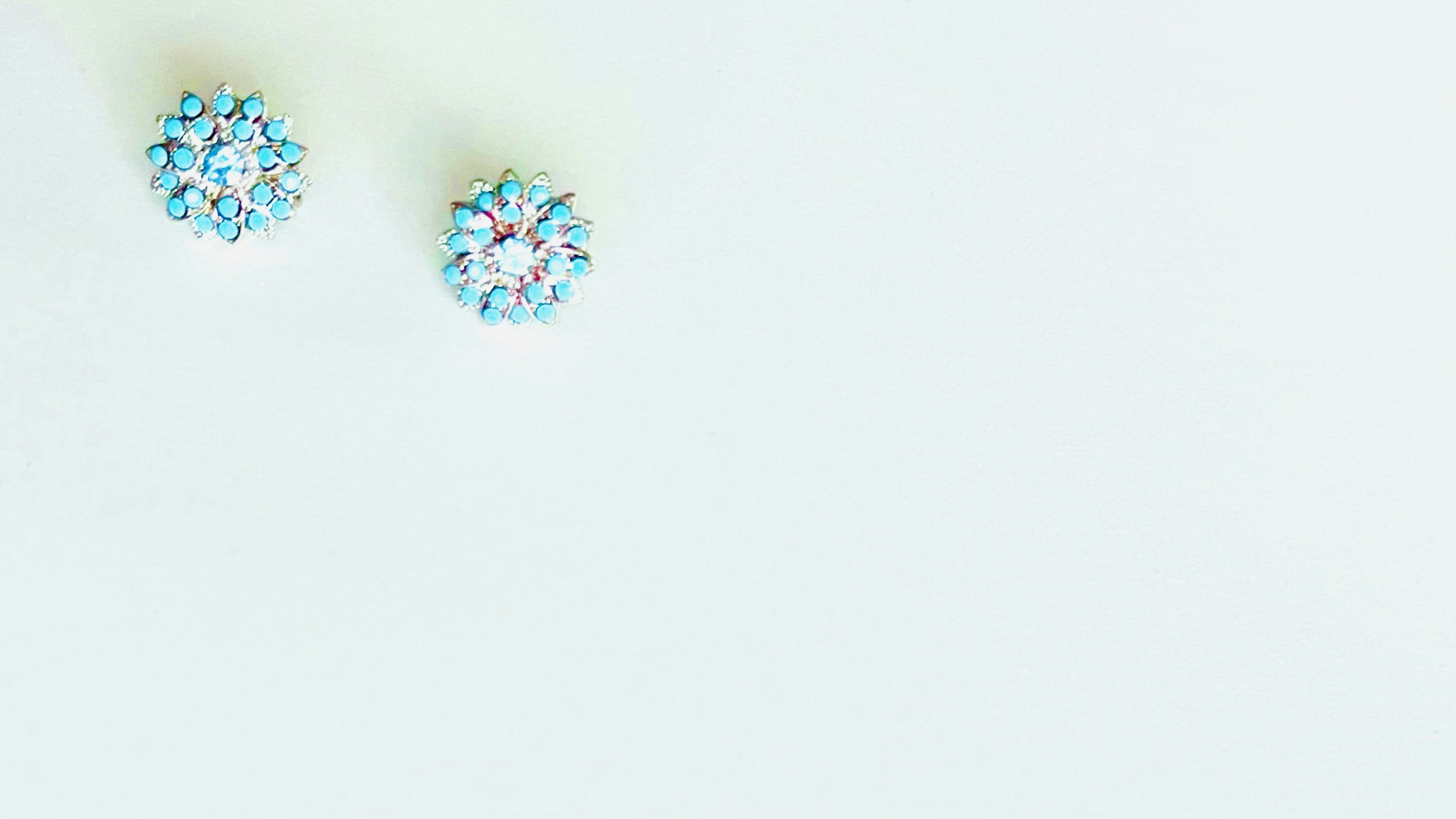 Blue gemstone earrings placed on a white background