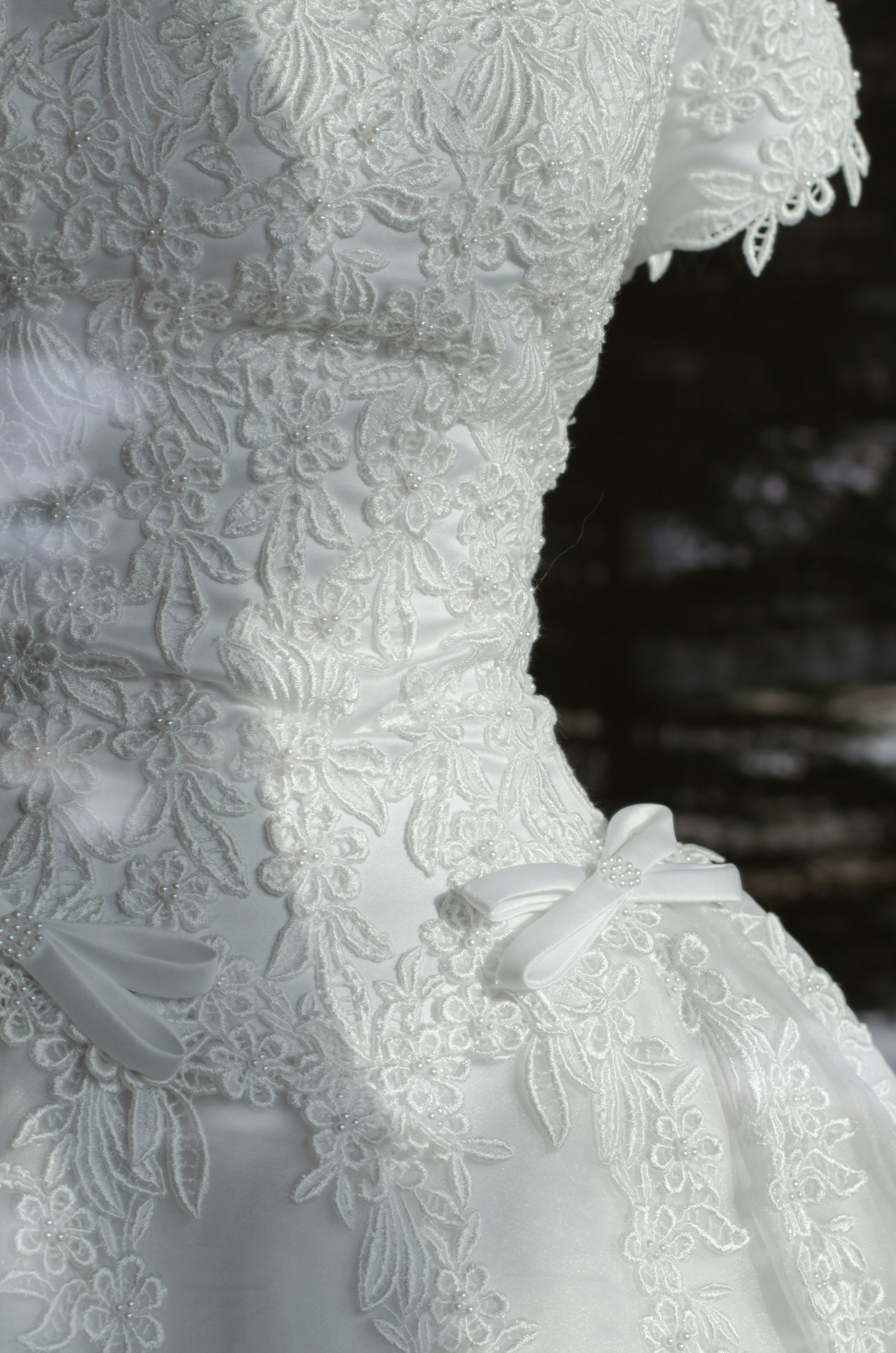 Sección de un vestido de novia blanco con bordado floral