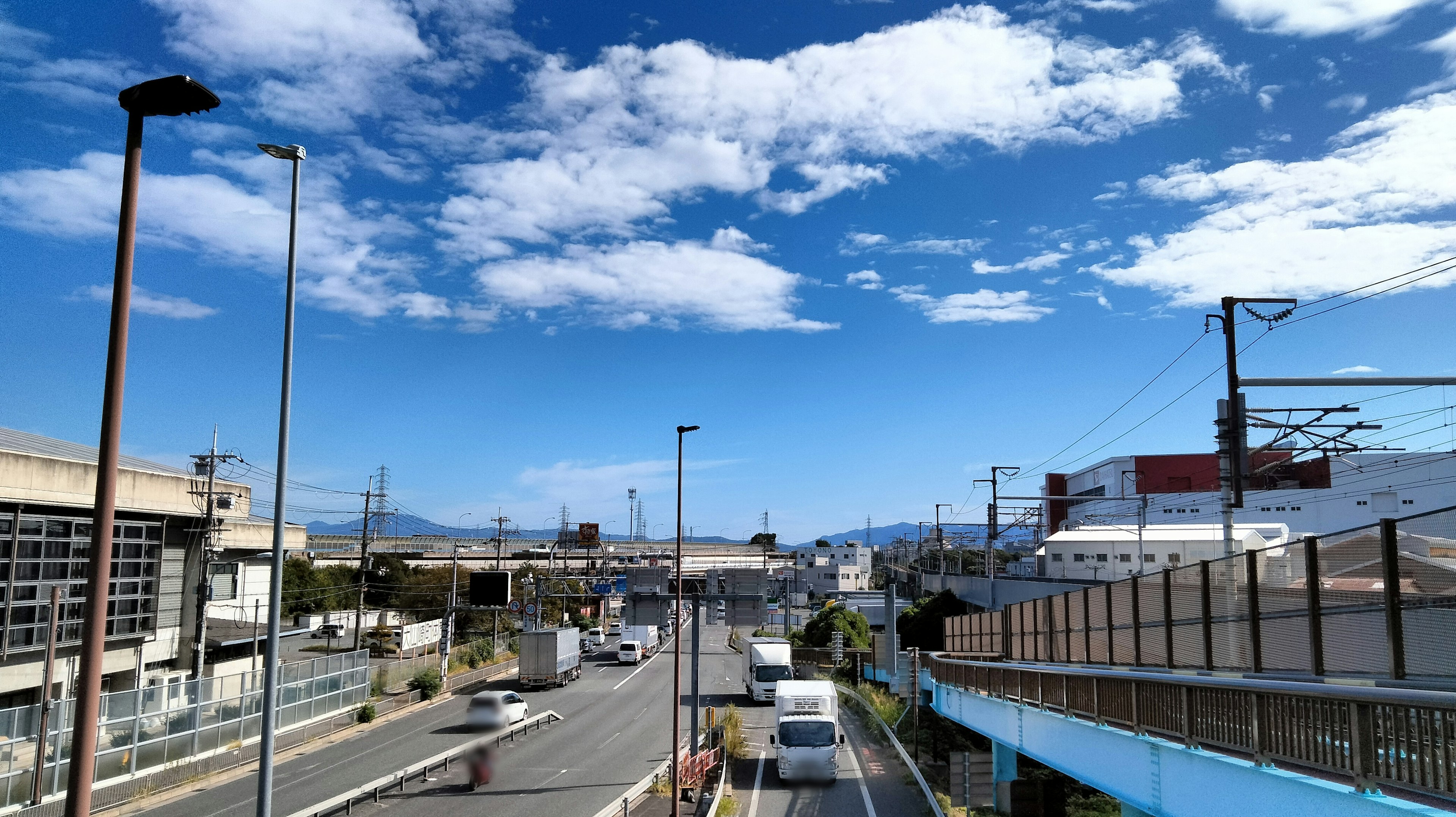 Urban road with buildings under a blue sky