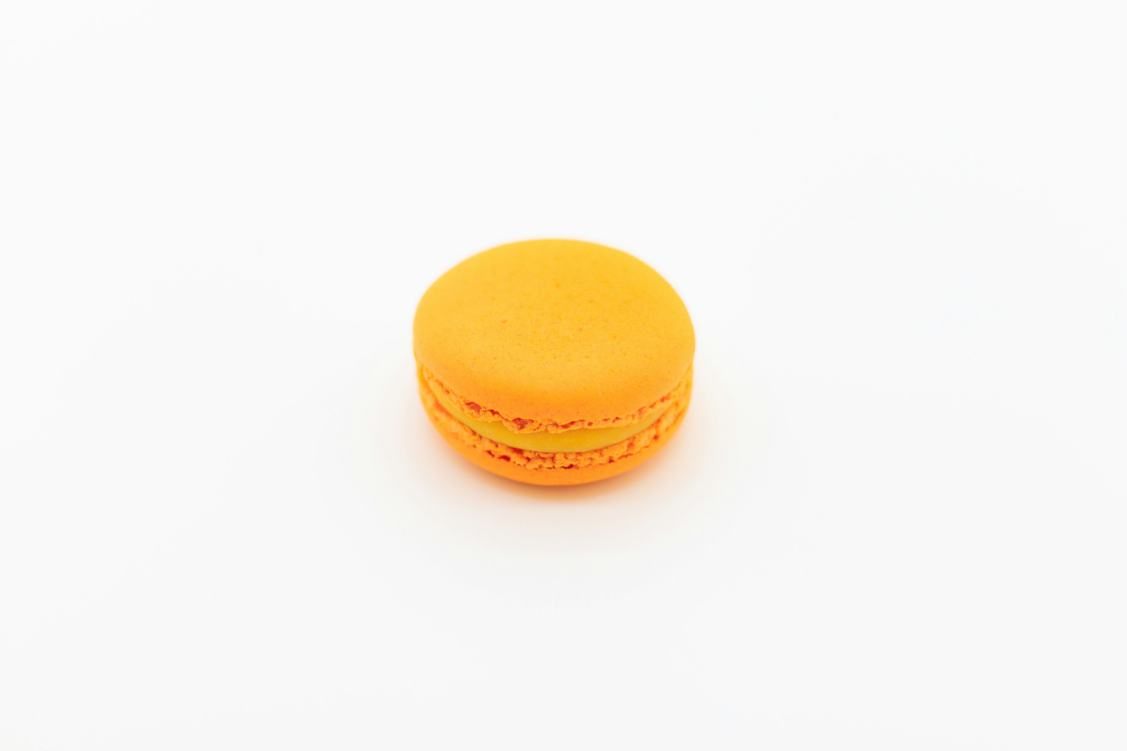 An orange macaron on a white background