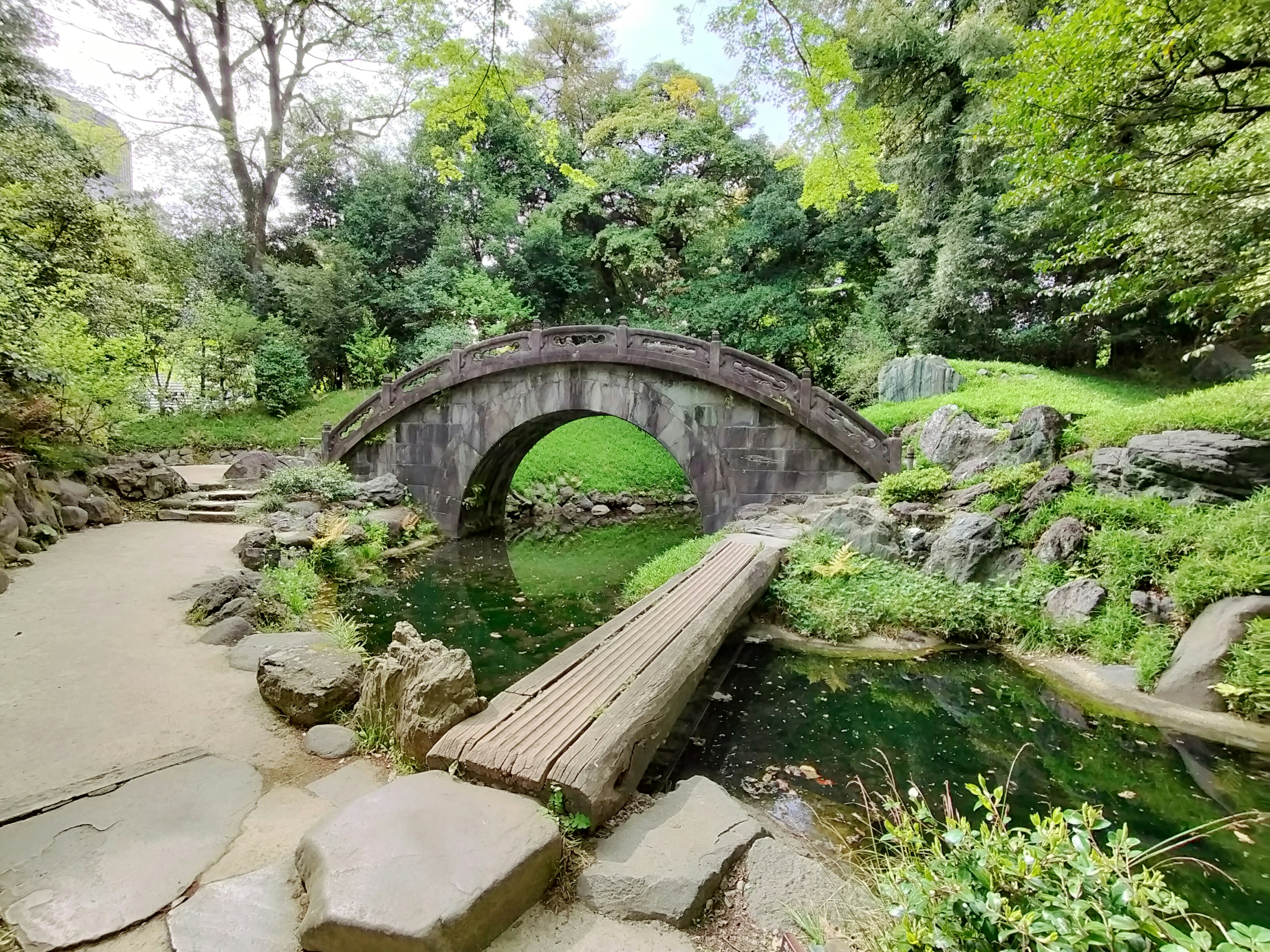 Eine schöne Steinbogenbrücke in einer üppigen japanischen Gartenlandschaft