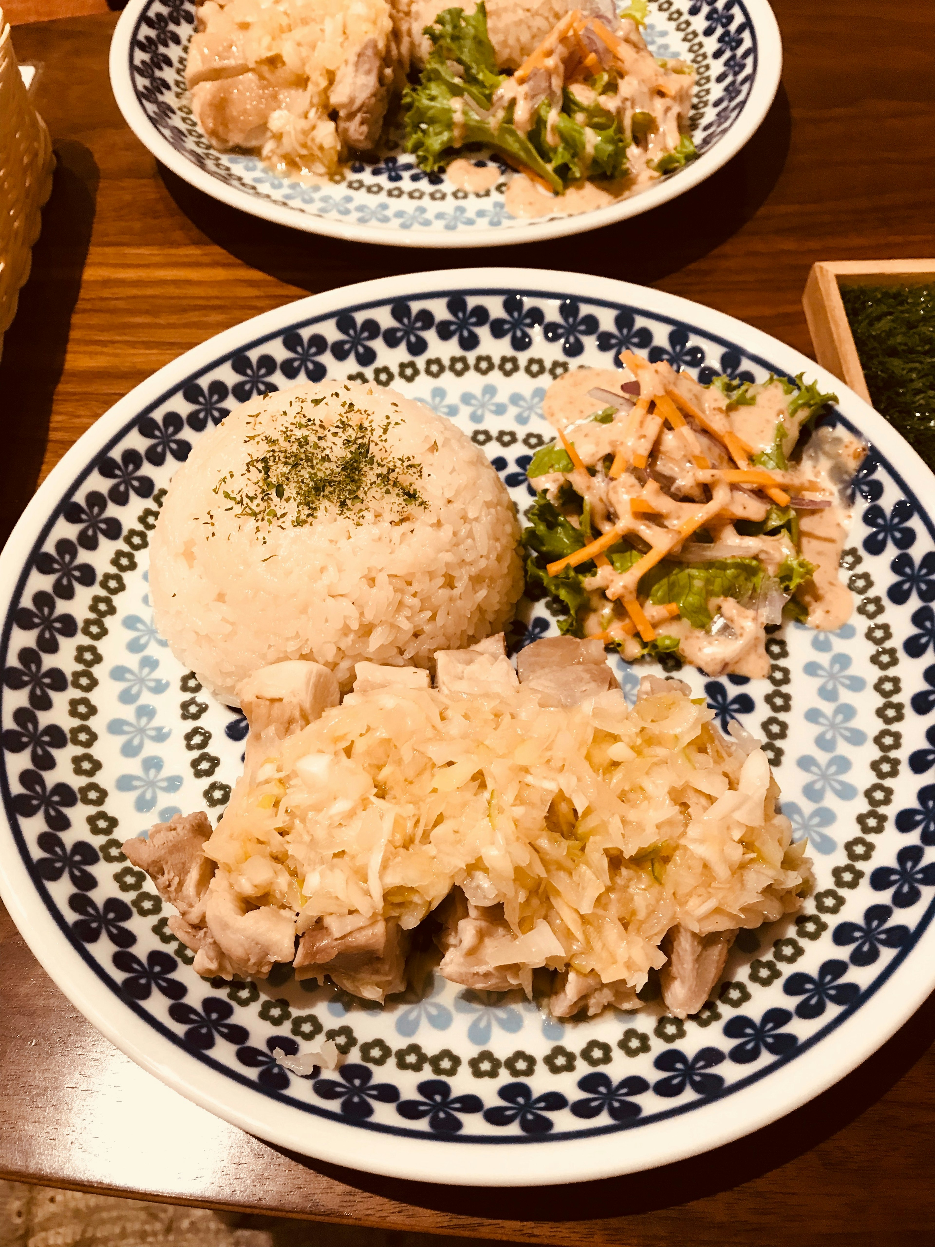 Teller mit Hähnchen und Kohl, begleitet von Reis und Salat