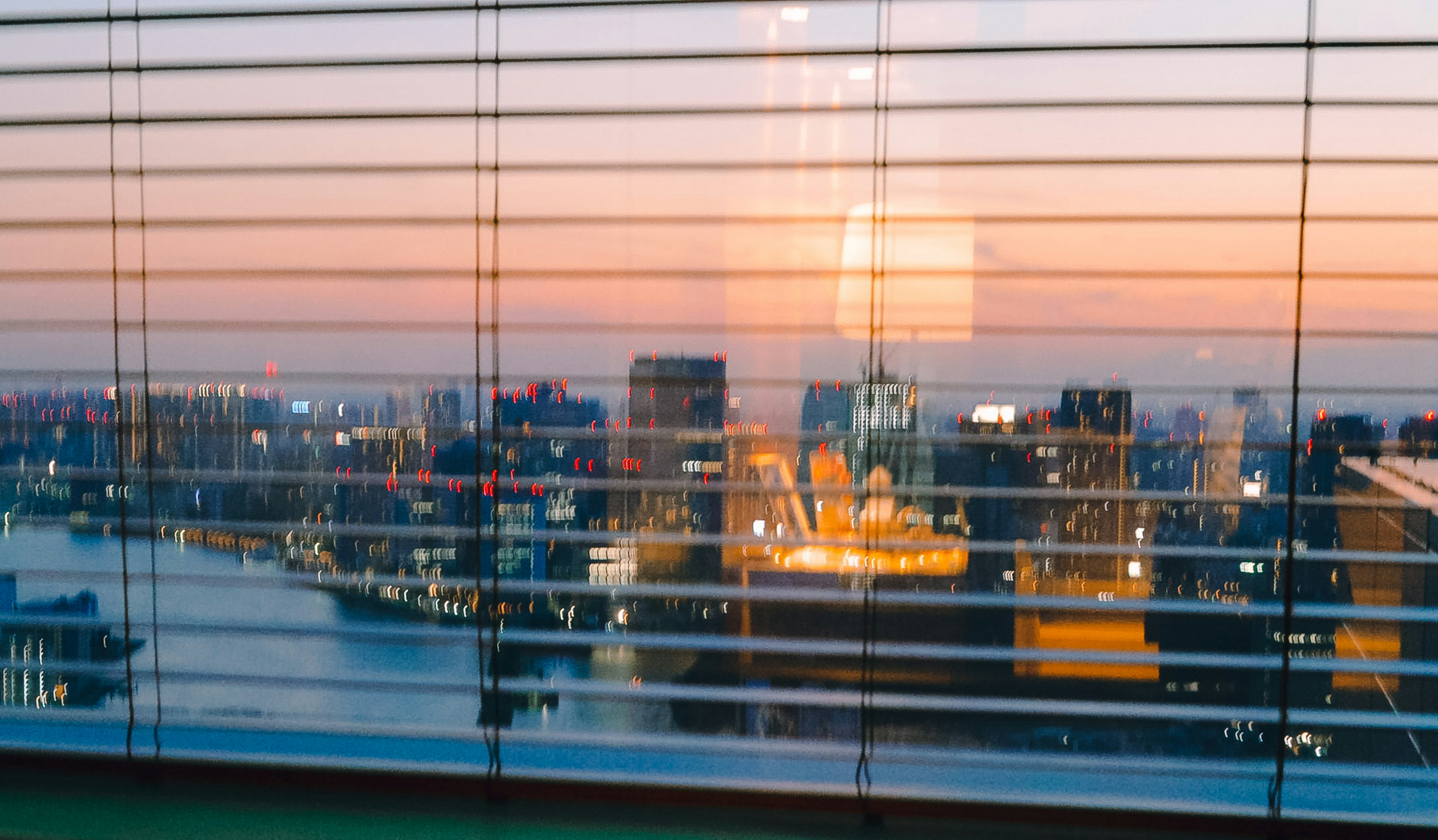 Stadtansicht bei Sonnenuntergang durch Jalousien