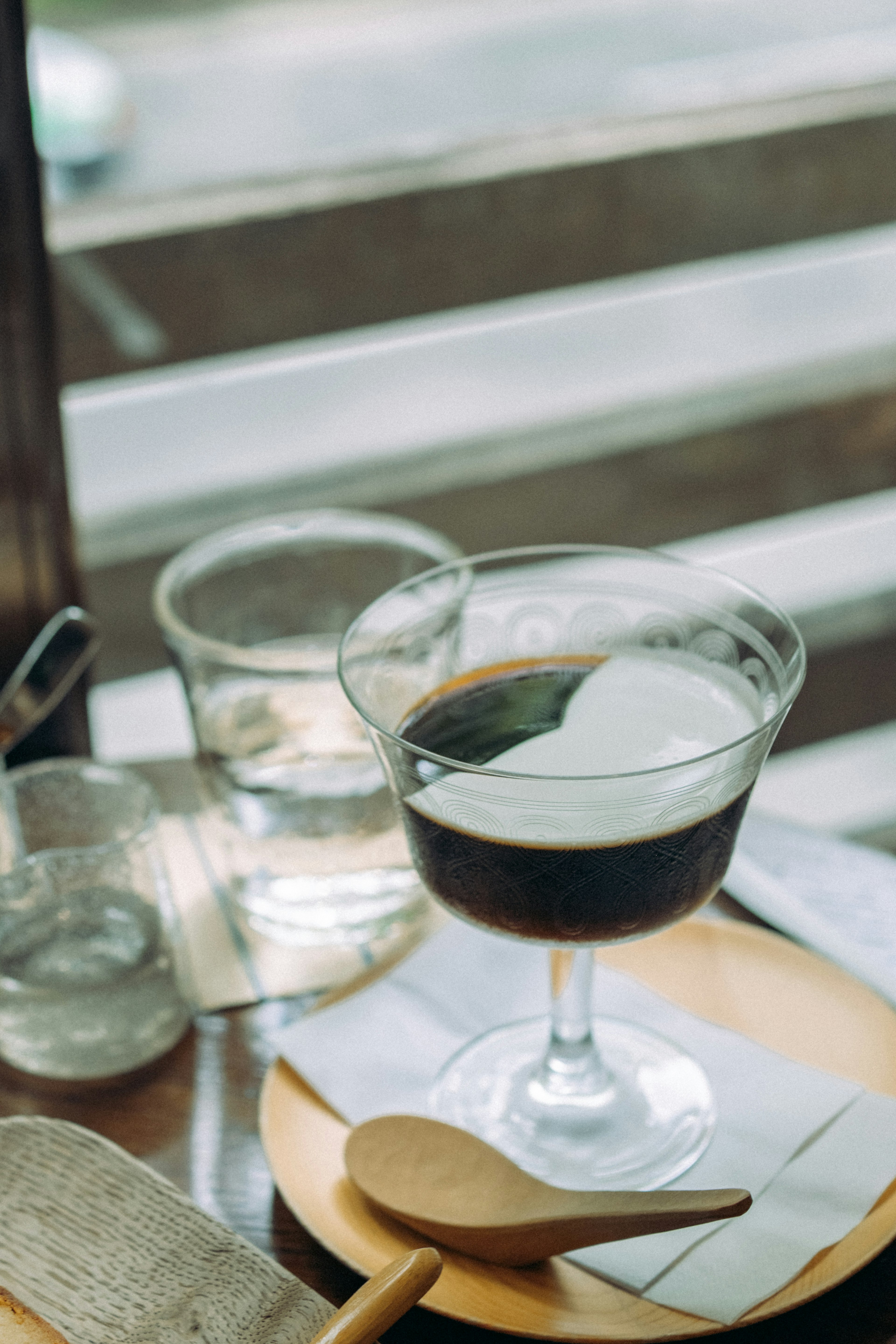 Ein Cocktail aus Kaffee und Sahne, serviert in einem Glas auf einem Holztisch