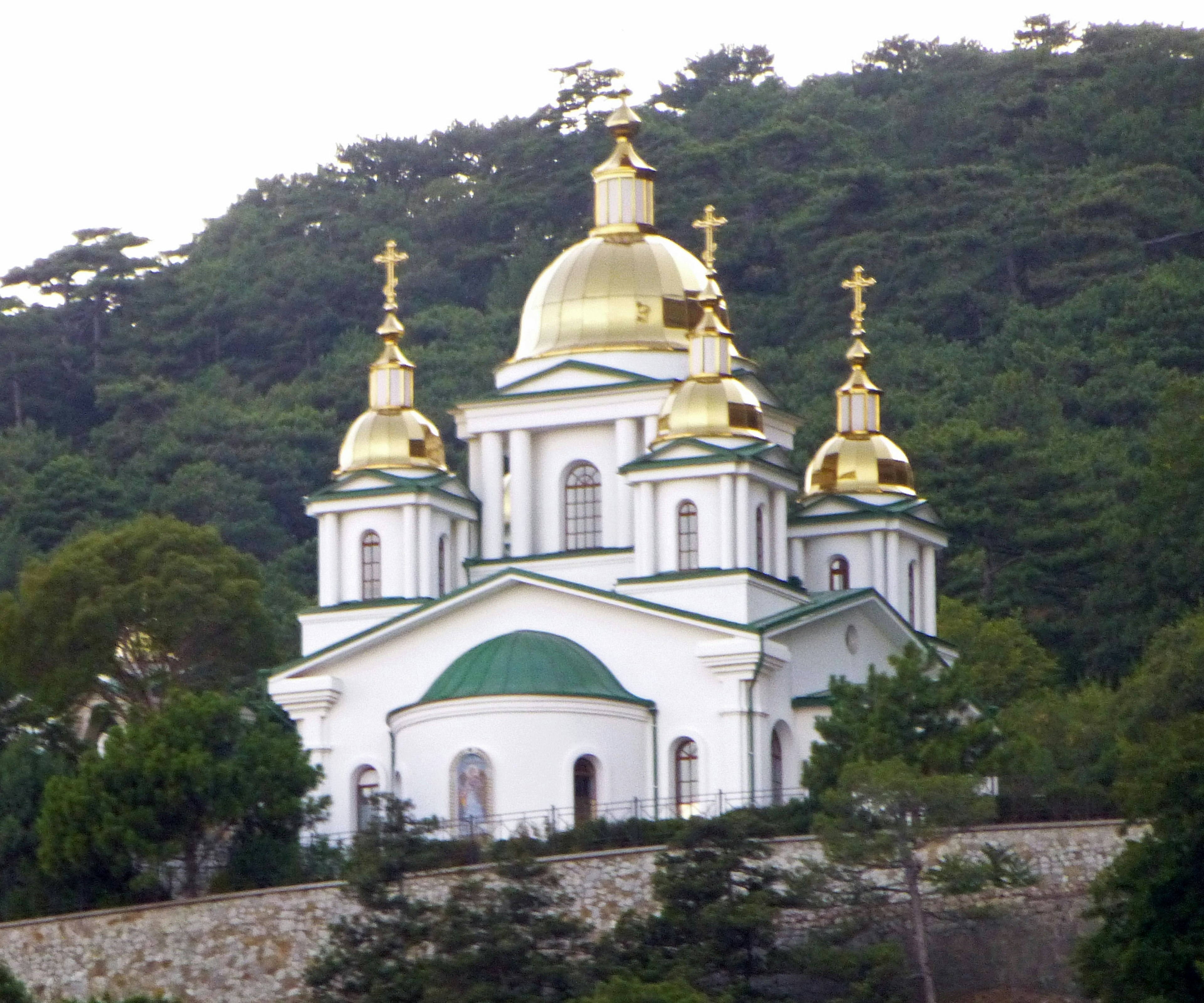 Hermosa iglesia con cúpulas doradas y fondo verde