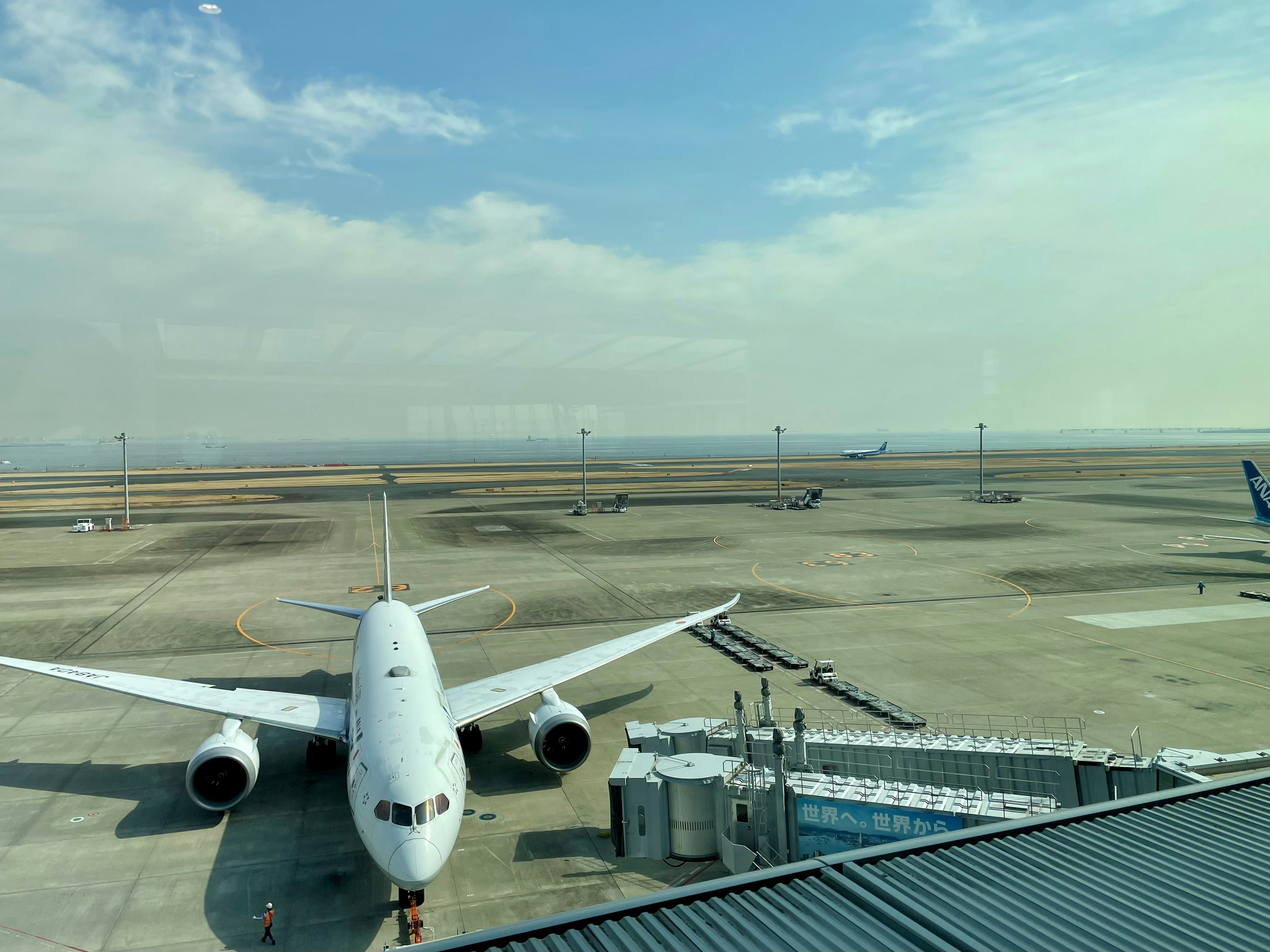 空港の滑走路に停まっている飛行機と広がる空