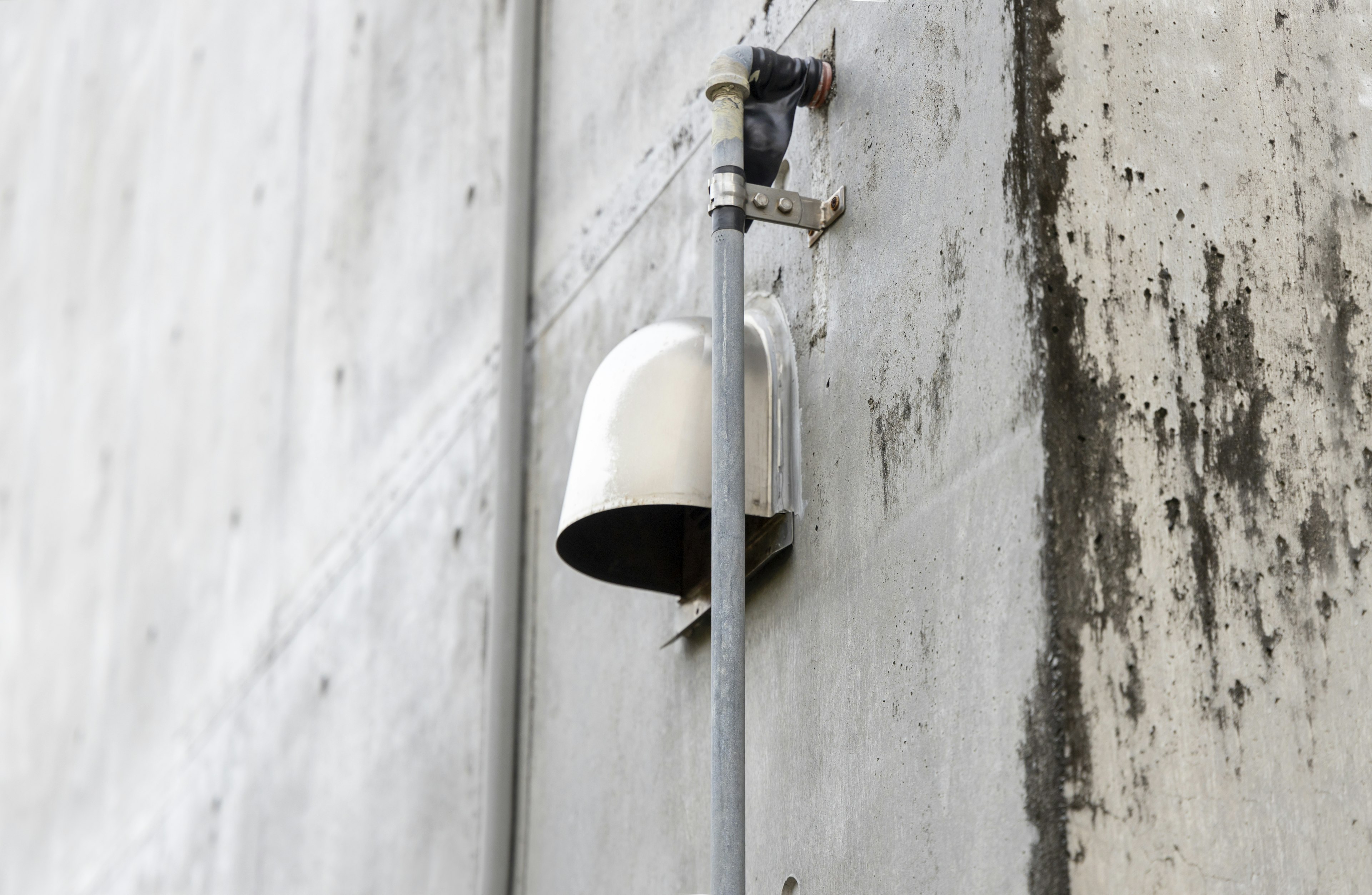 A white bell mounted on a wall