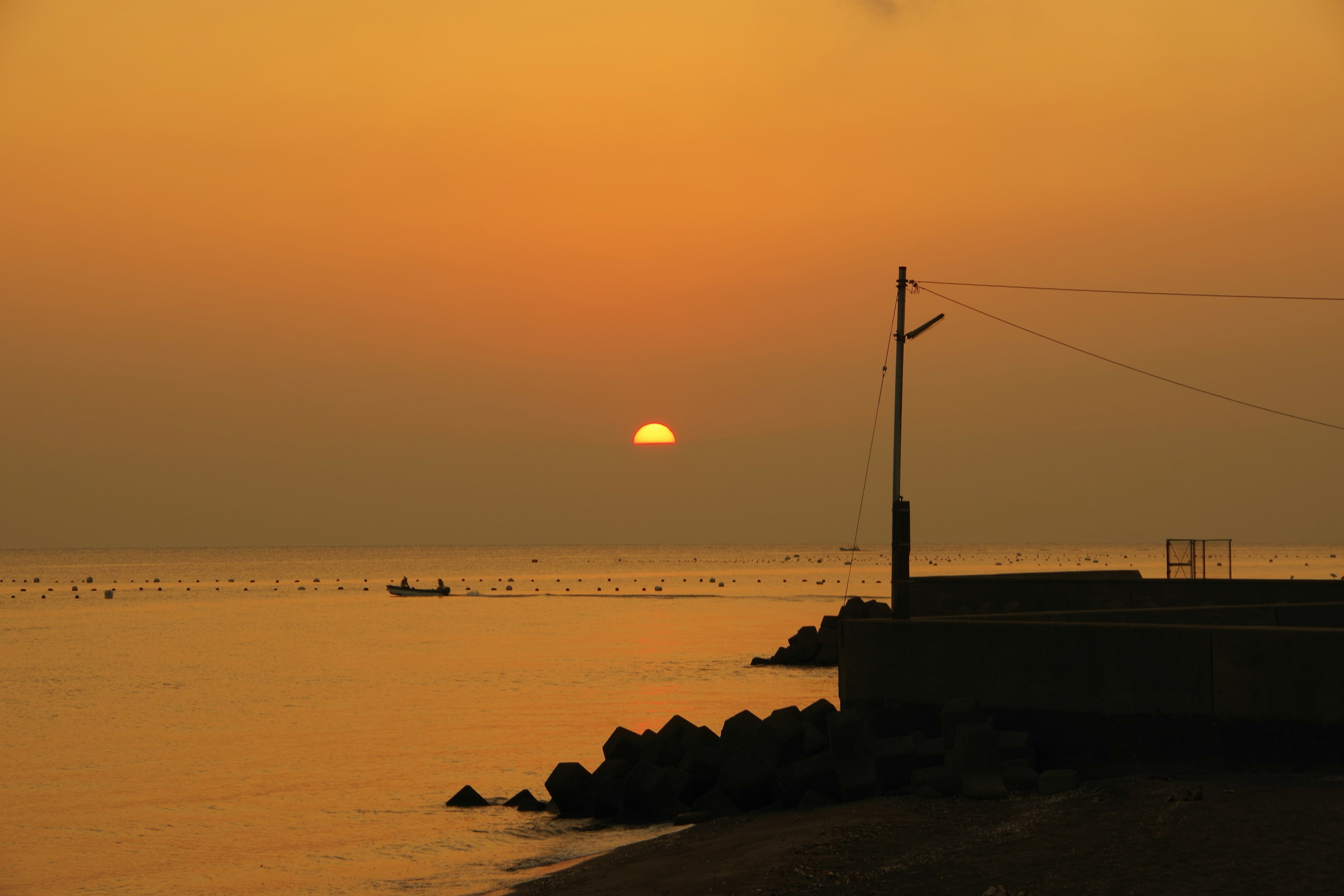 Küstenansicht mit Sonnenuntergang, der sich im Wasser spiegelt