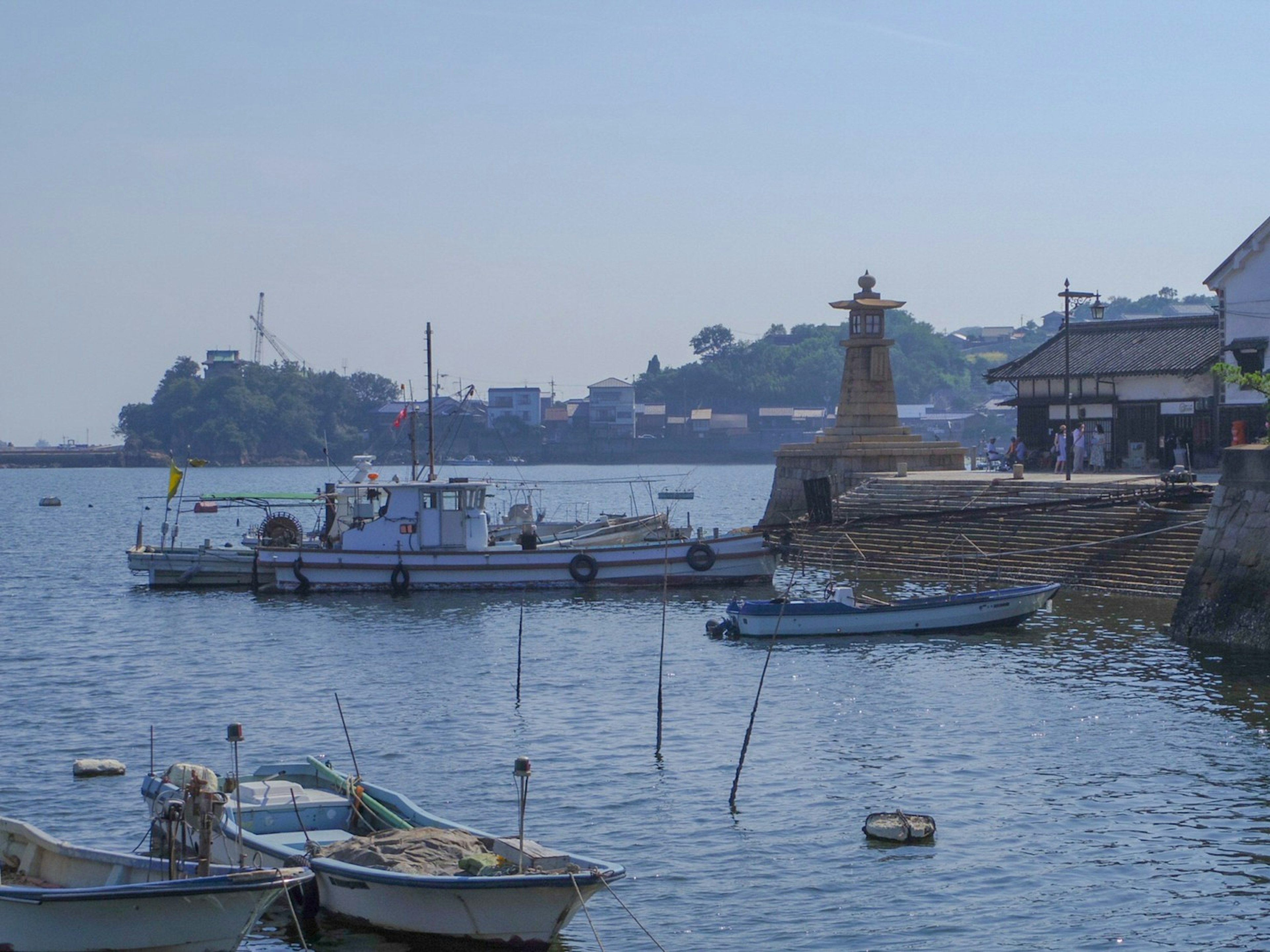 Serene harbor with small boats and a lighthouse