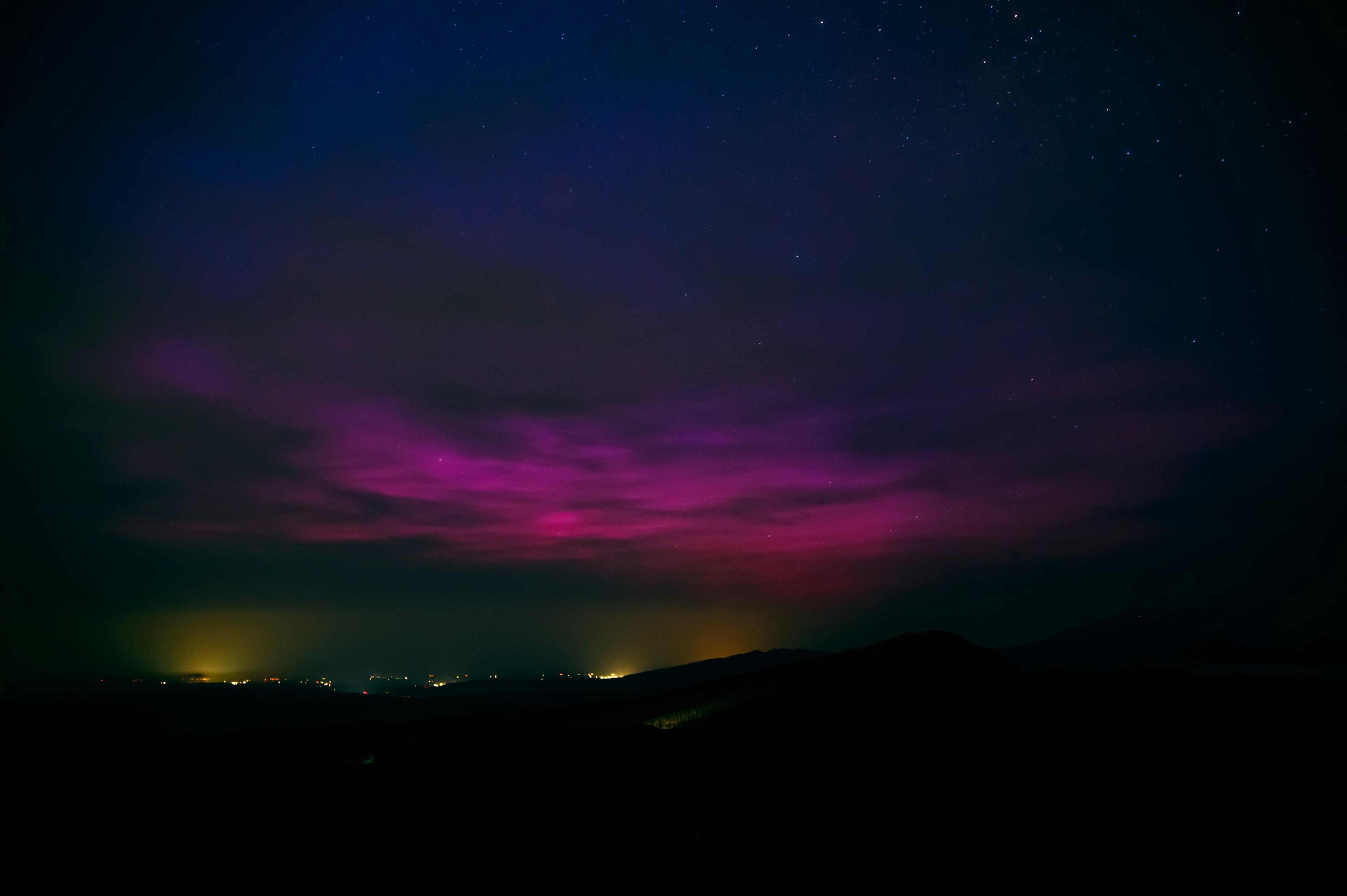 Un cielo nocturno con auroras moradas vibrantes y estrellas dispersas