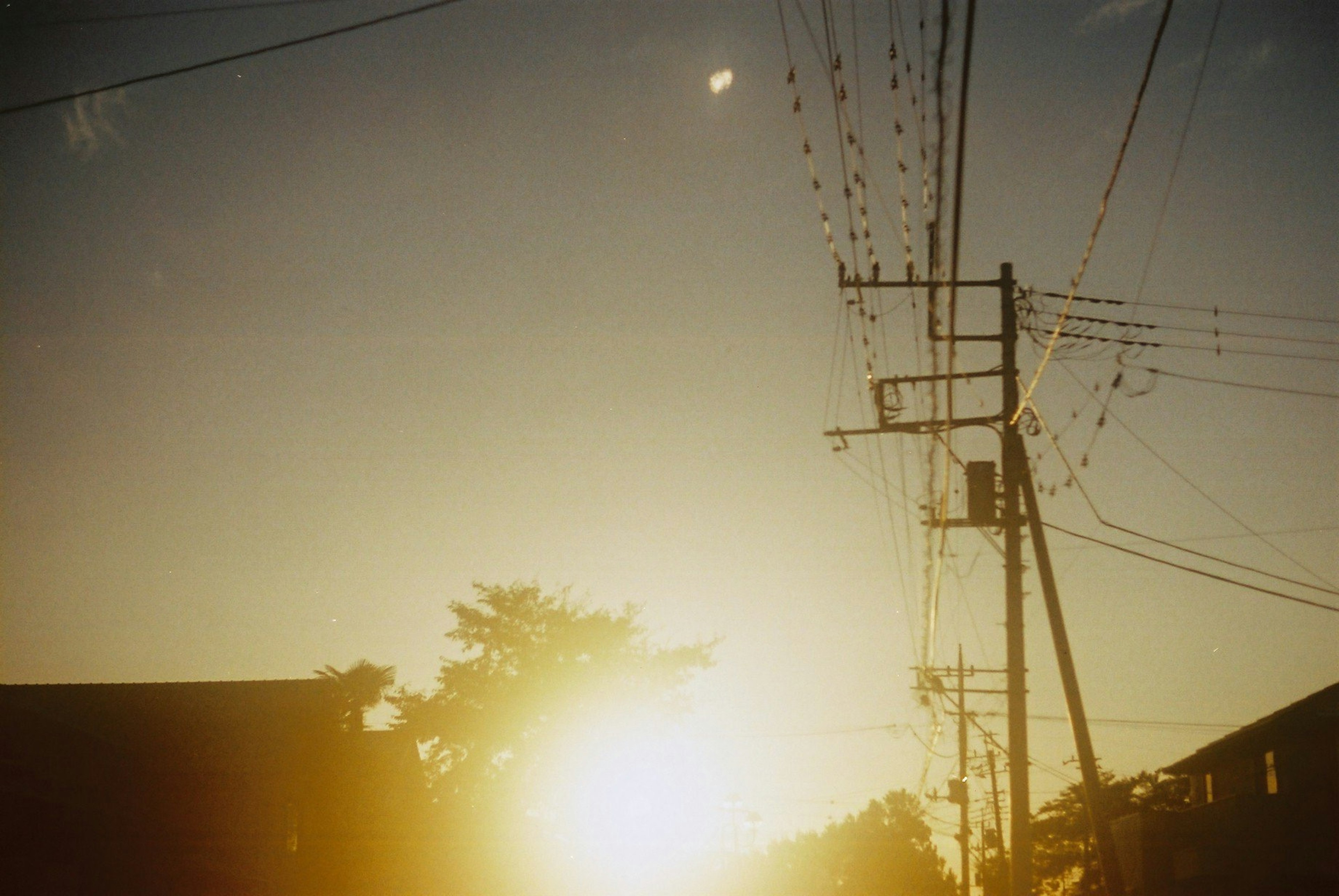 夕日が輝く街の風景と電線