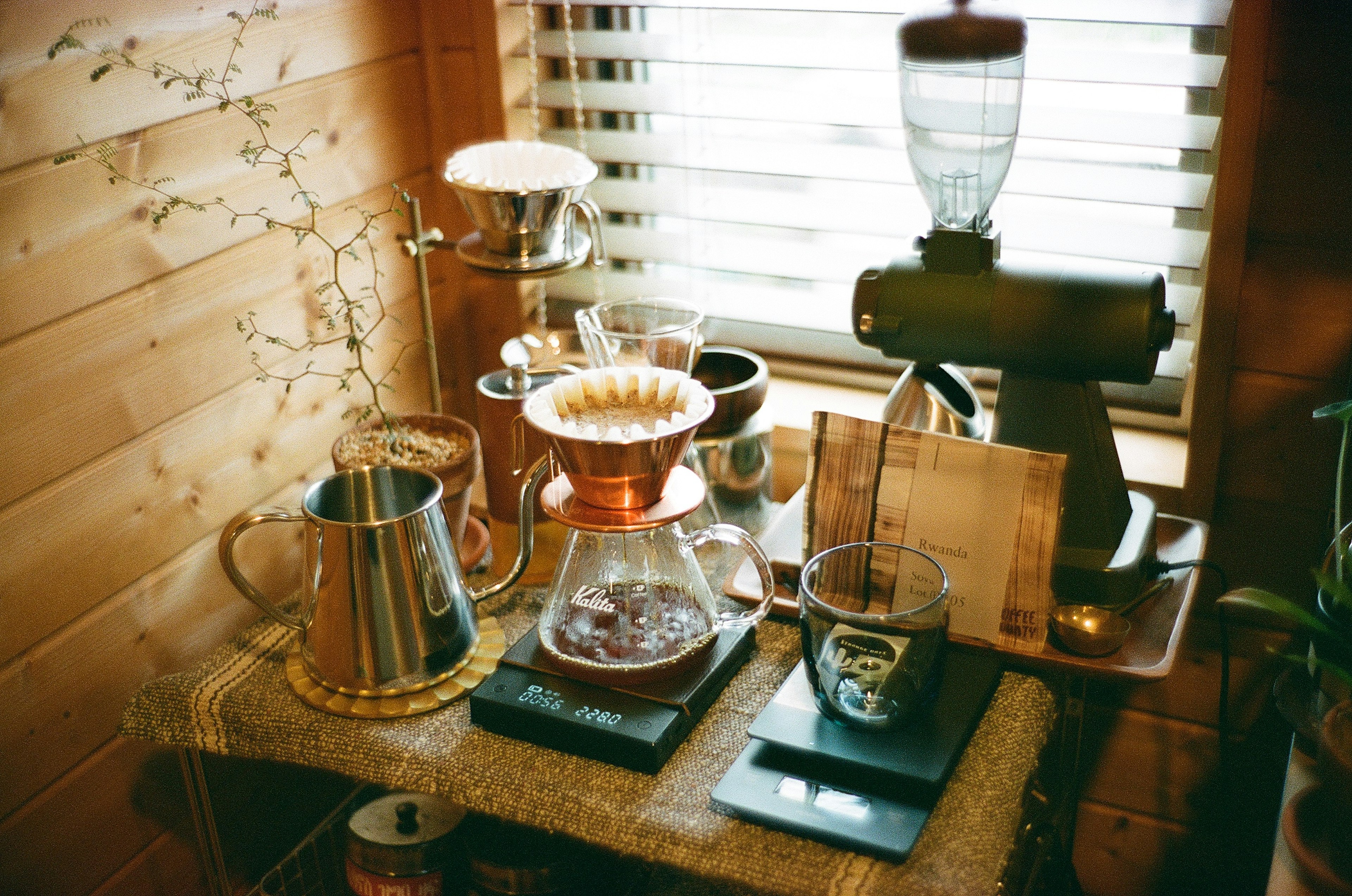 Un acogedor rincón de café con varios equipos de preparación en un mostrador de madera