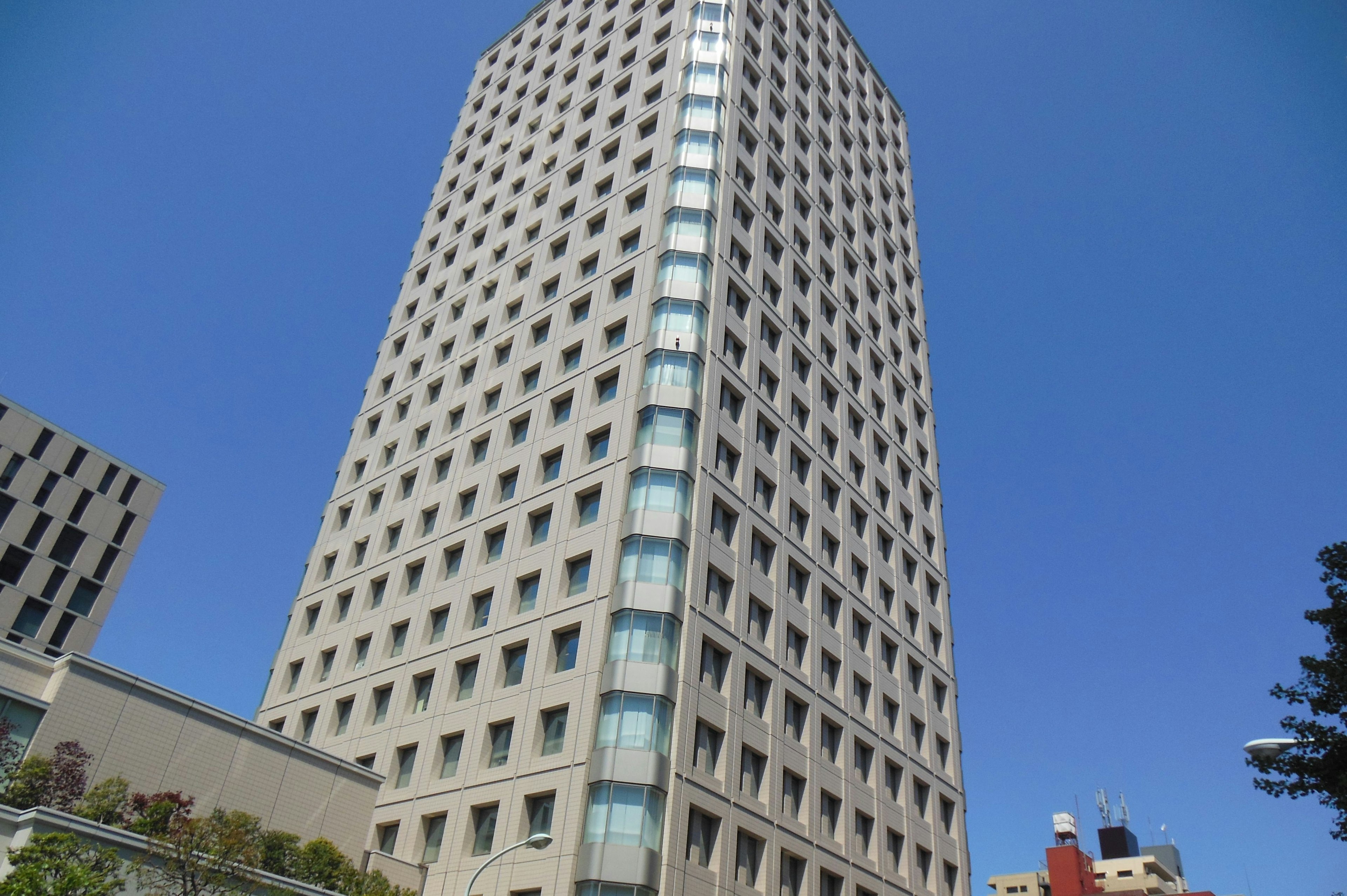 Fachada de un edificio alto con diseño moderno bajo un cielo azul