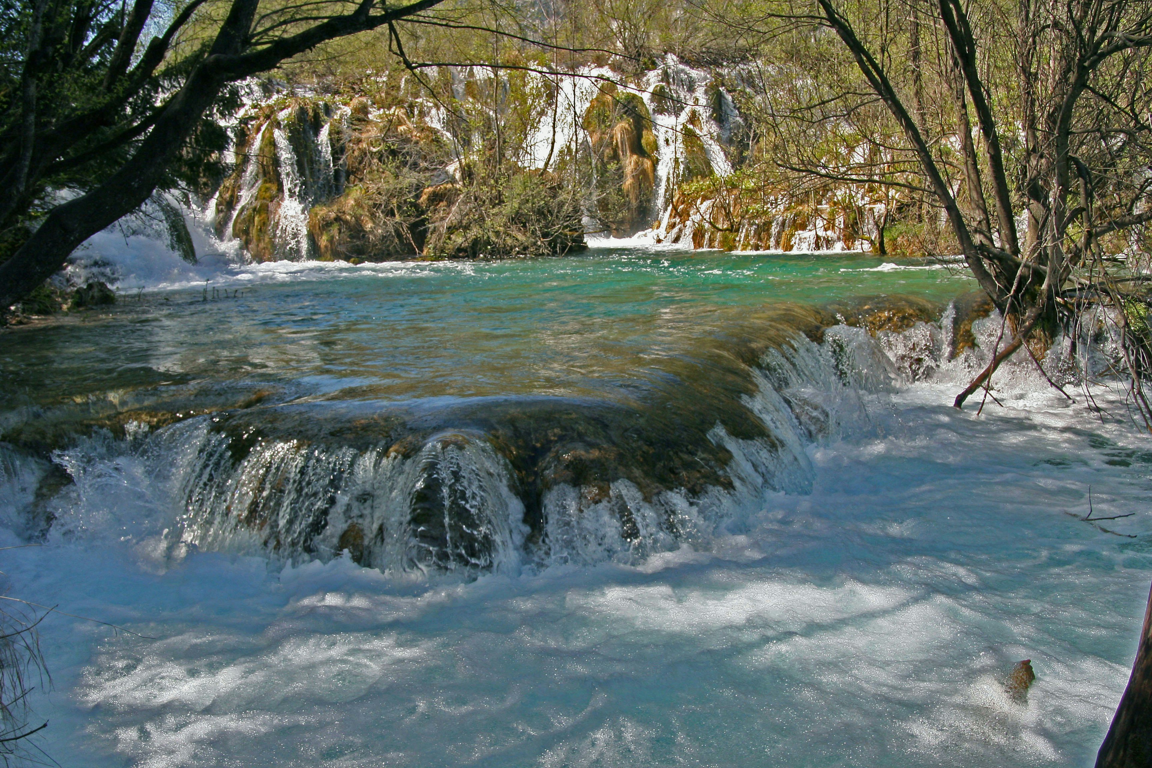 A scenic view of cascading waterfalls and turquoise waters in nature