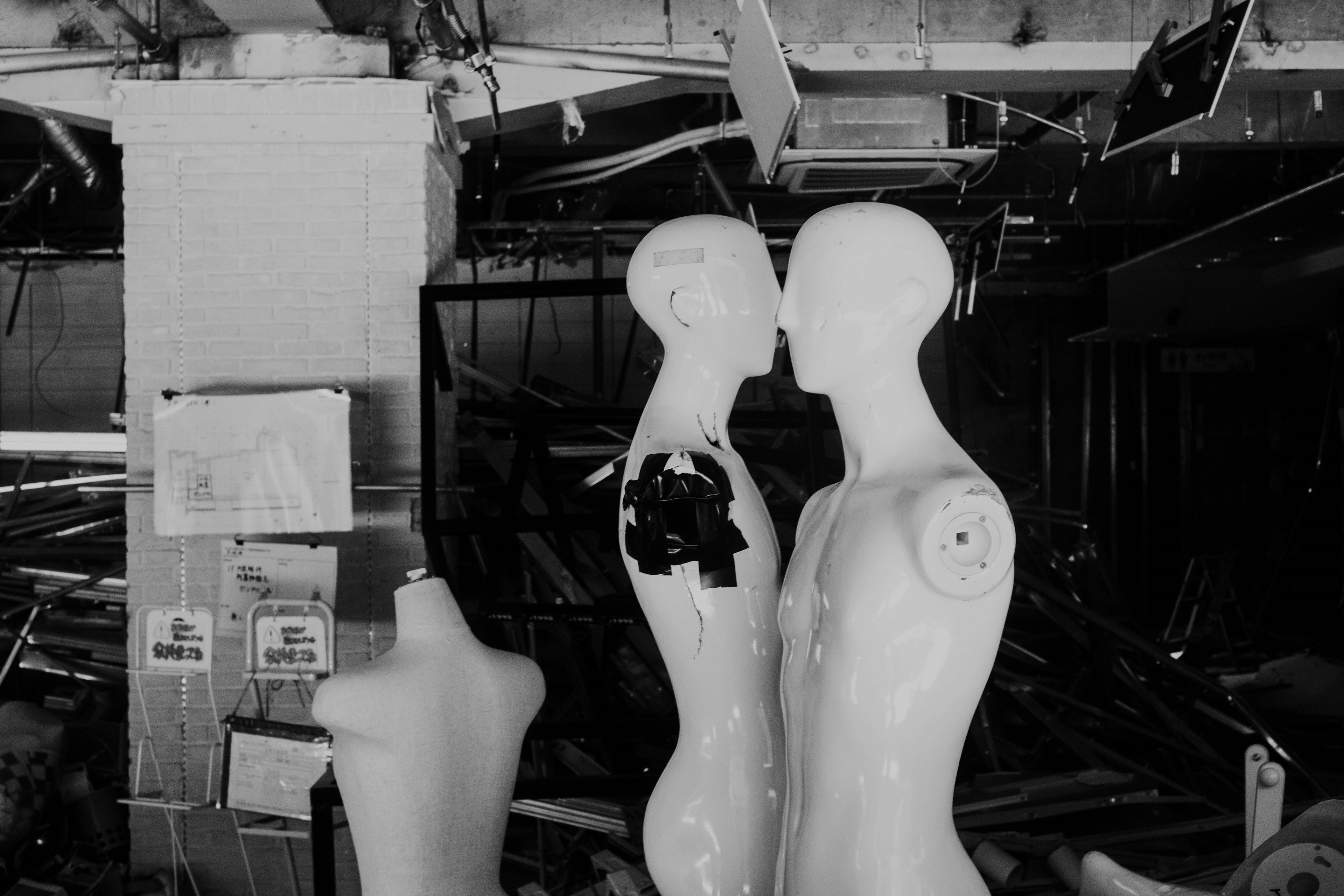 Mannequins blancs positionnés dans un espace en désordre et abandonné