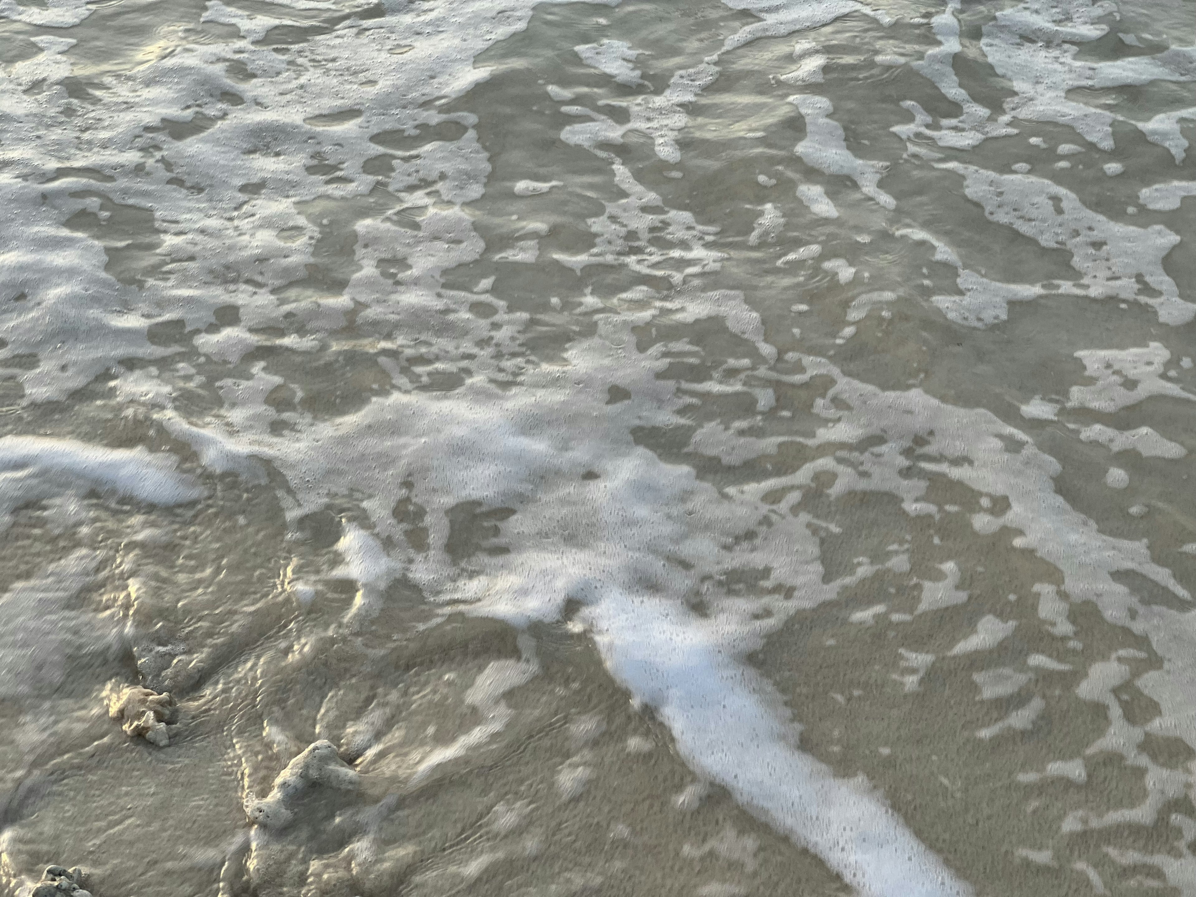 Gentle waves lapping on the sandy beach surface