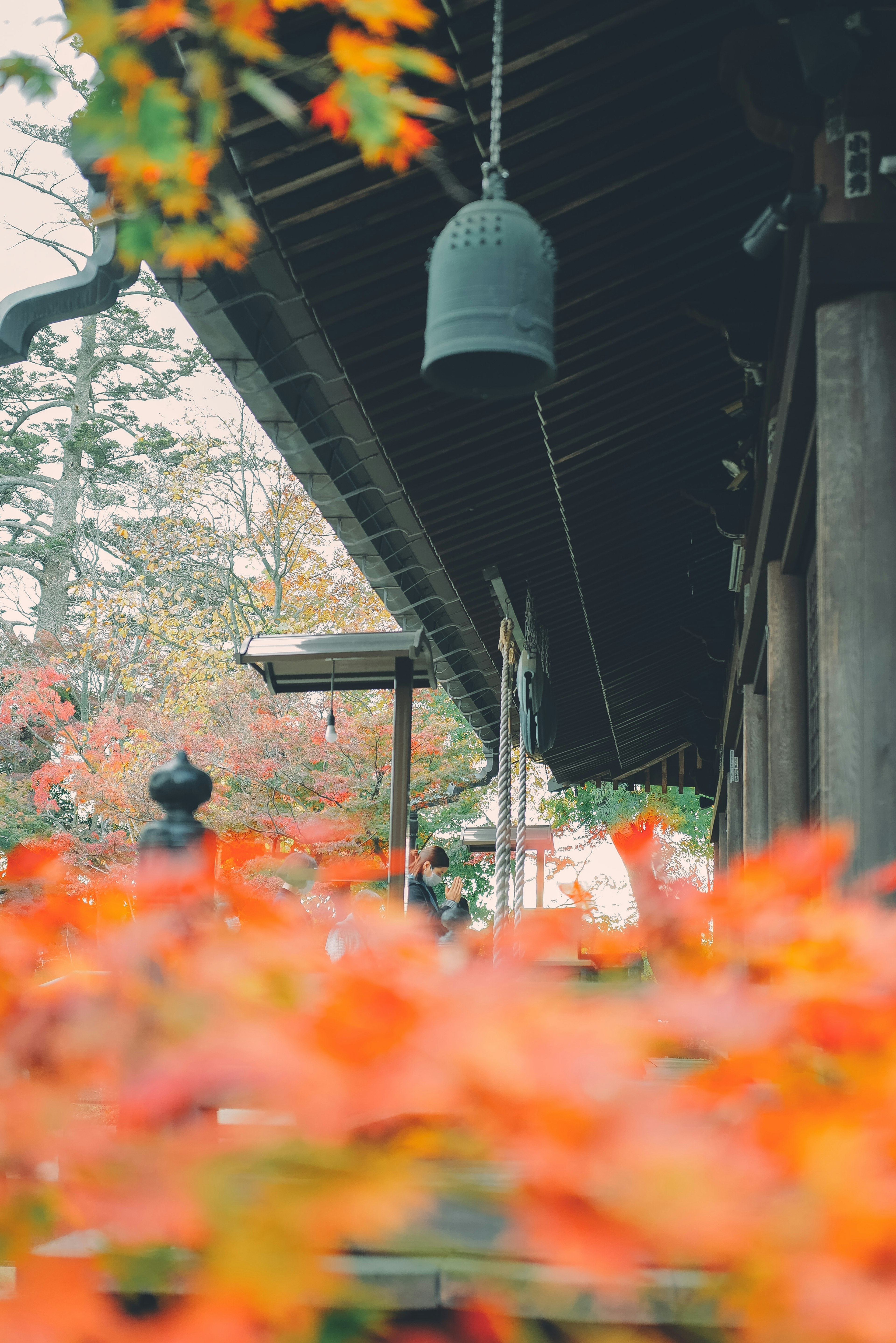 Lebendige Herbstblätter mit einer alten Tempelglocke