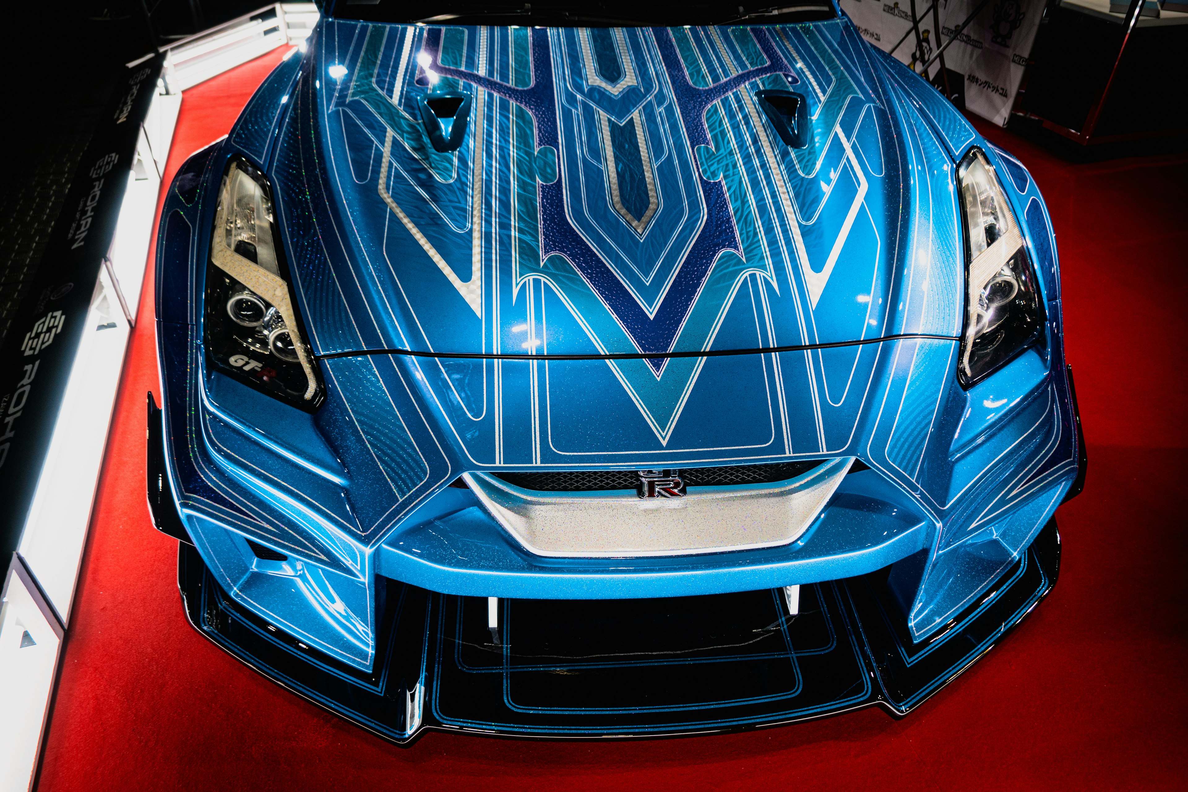 Top view of a blue sports car featuring intricate graphic patterns