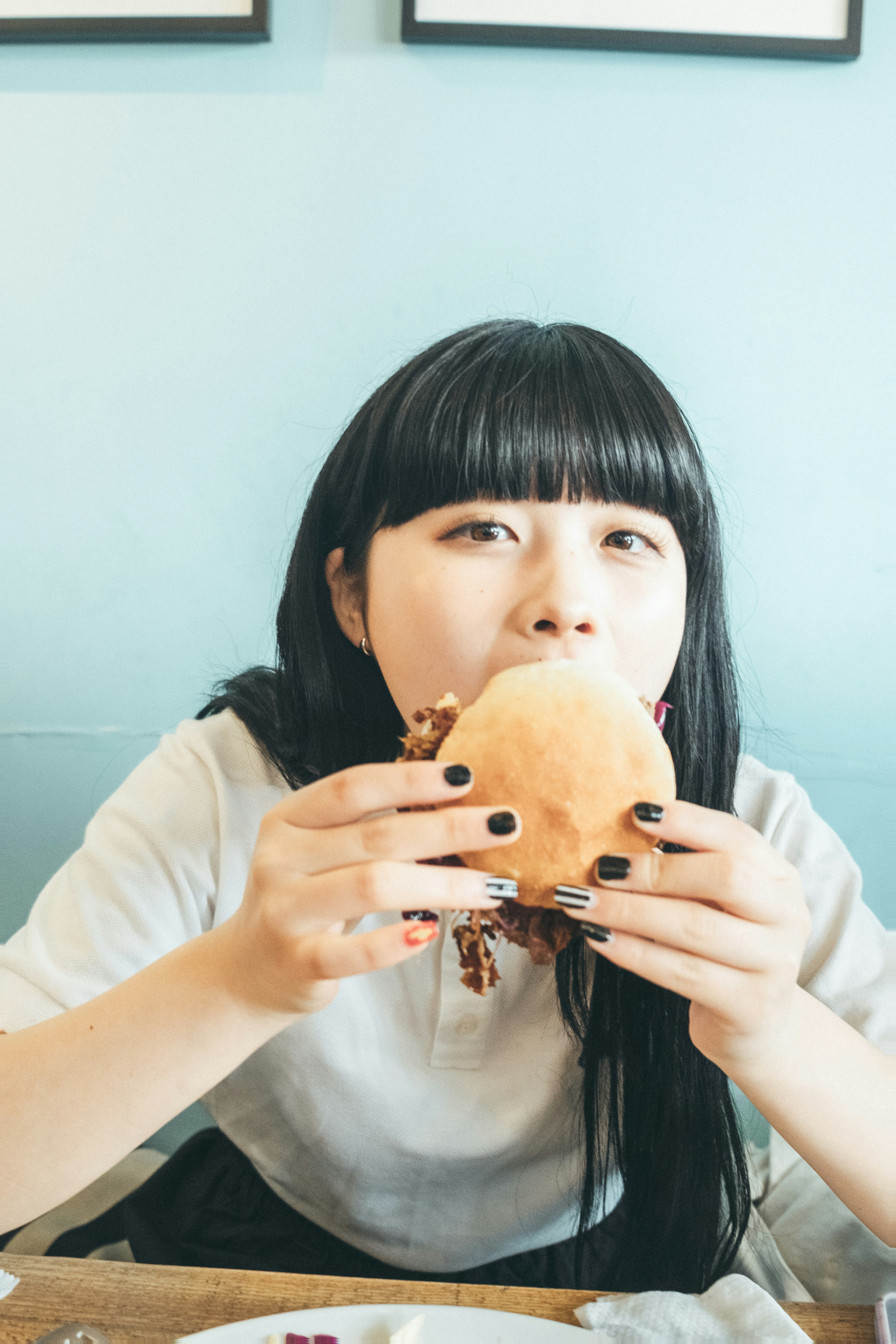 여성이 큰 햄버거를 들고 있다