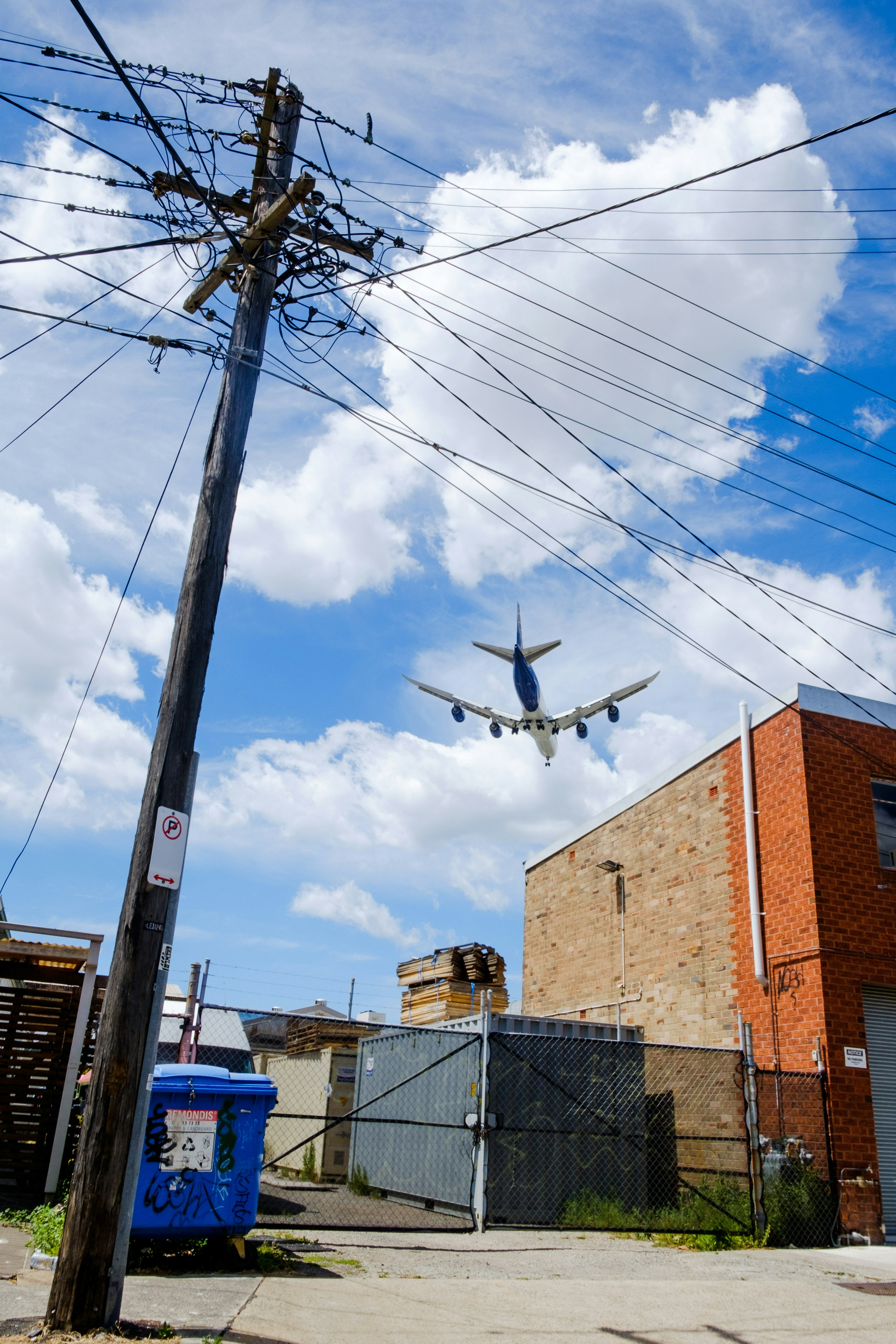 Un avión volando bajo sobre líneas eléctricas en un entorno urbano