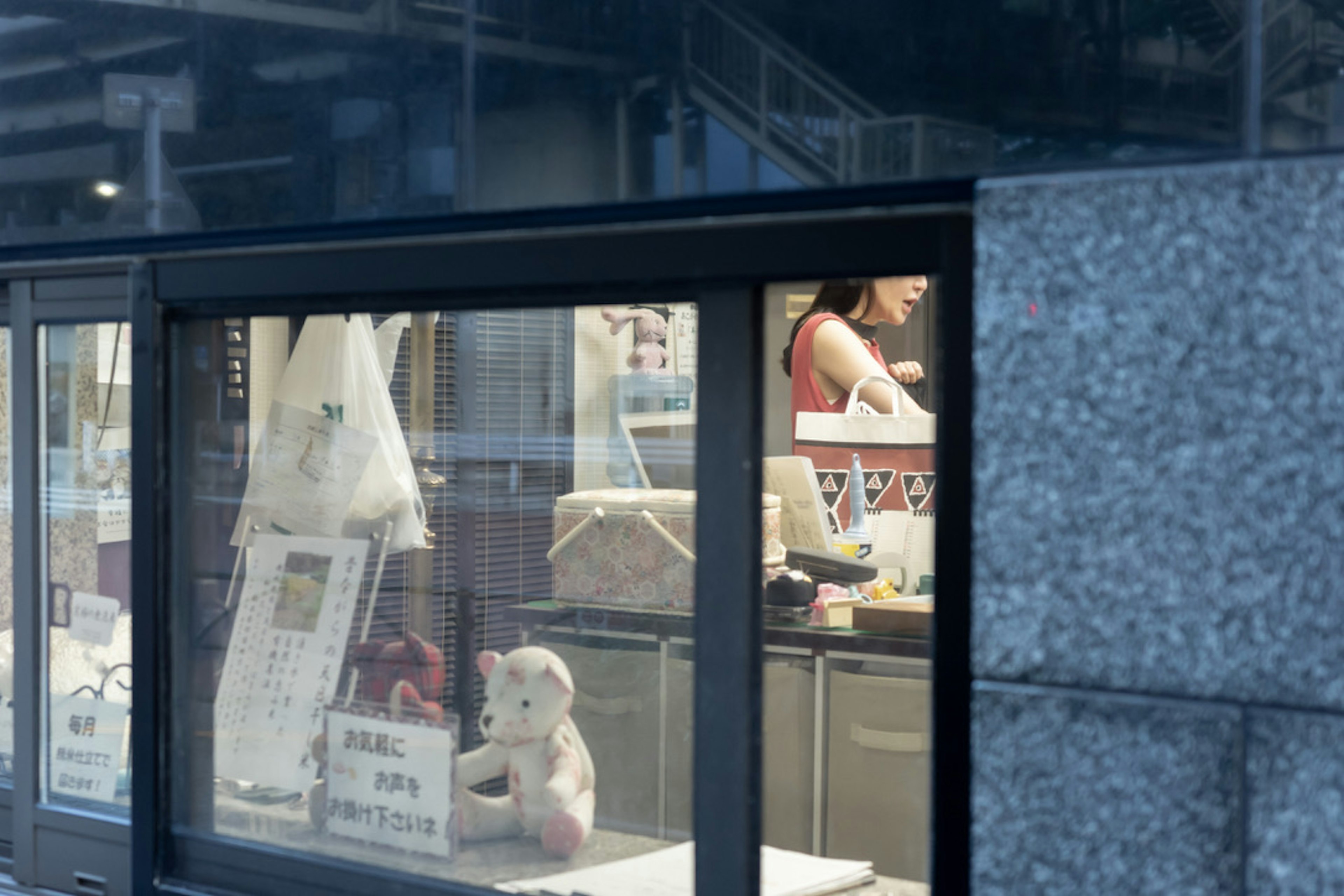 Vue de l'intérieur d'un magasin à travers une vitre avec une employée