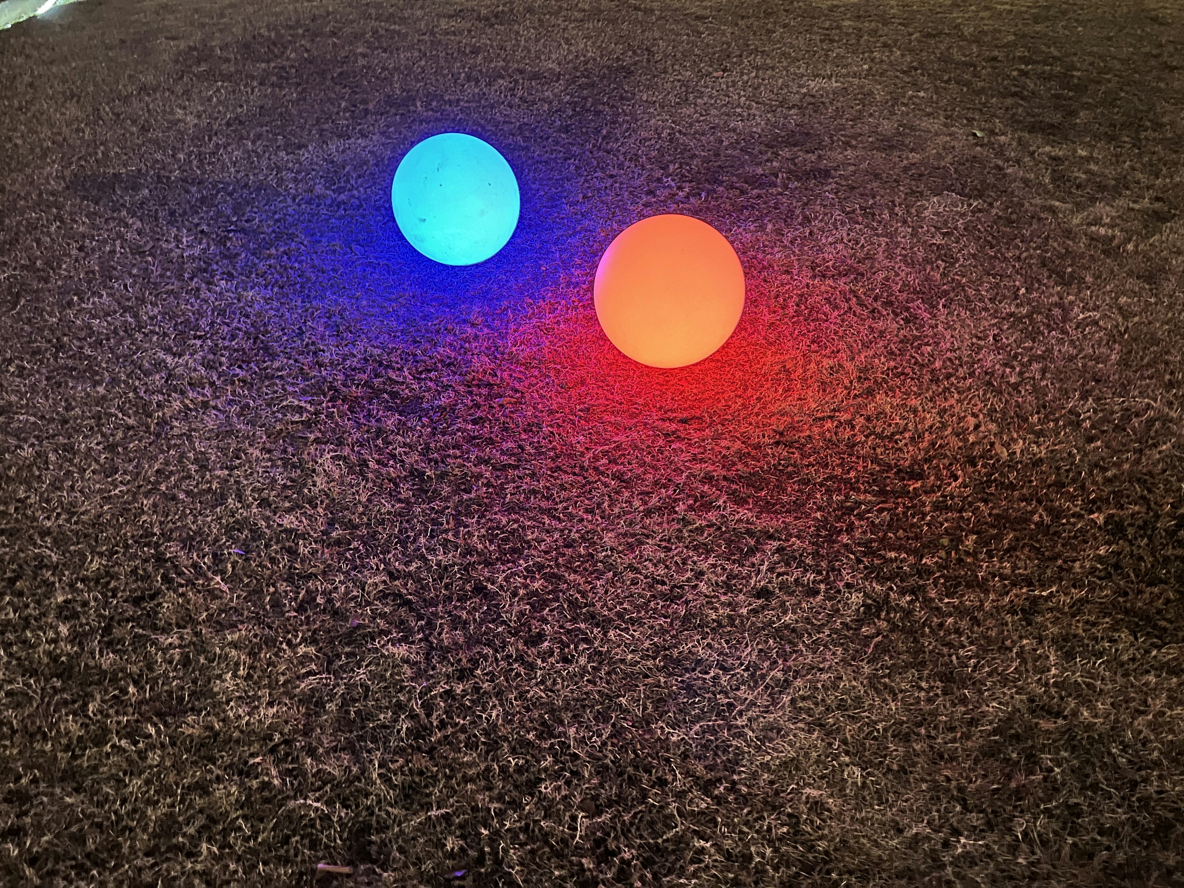 Blue and red glowing spheres placed on a brown surface