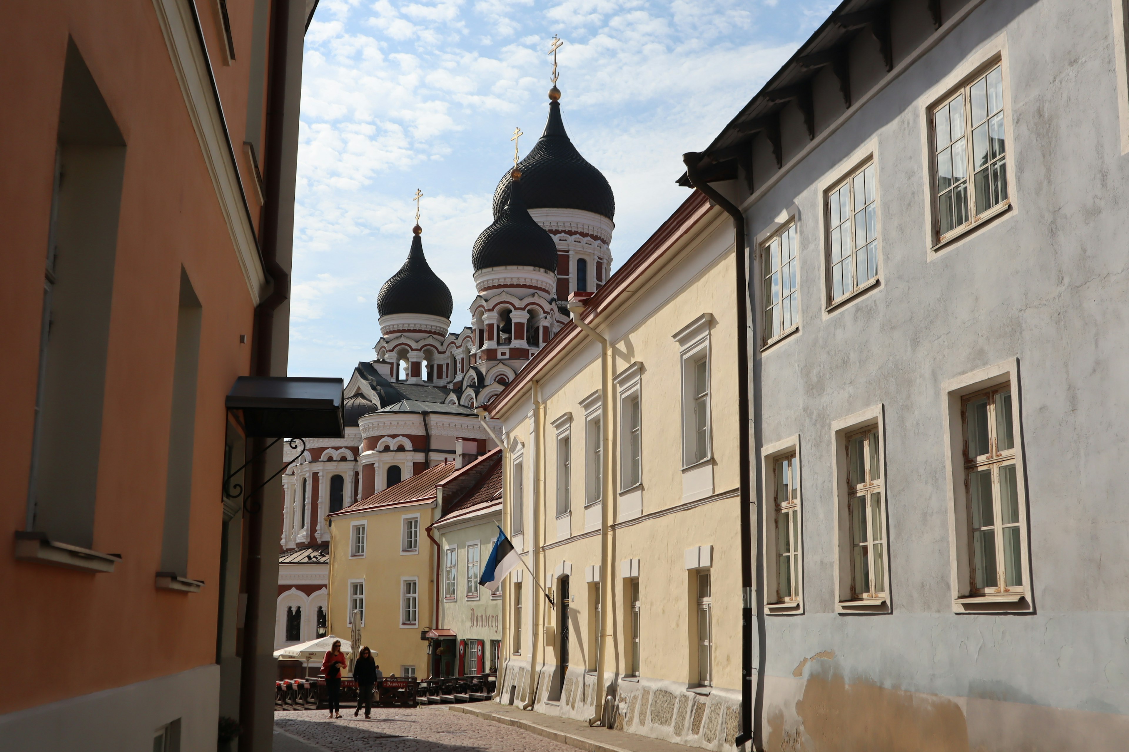 Narrow street in Tallinn Estonia featuring historical buildings and a prominent church dome