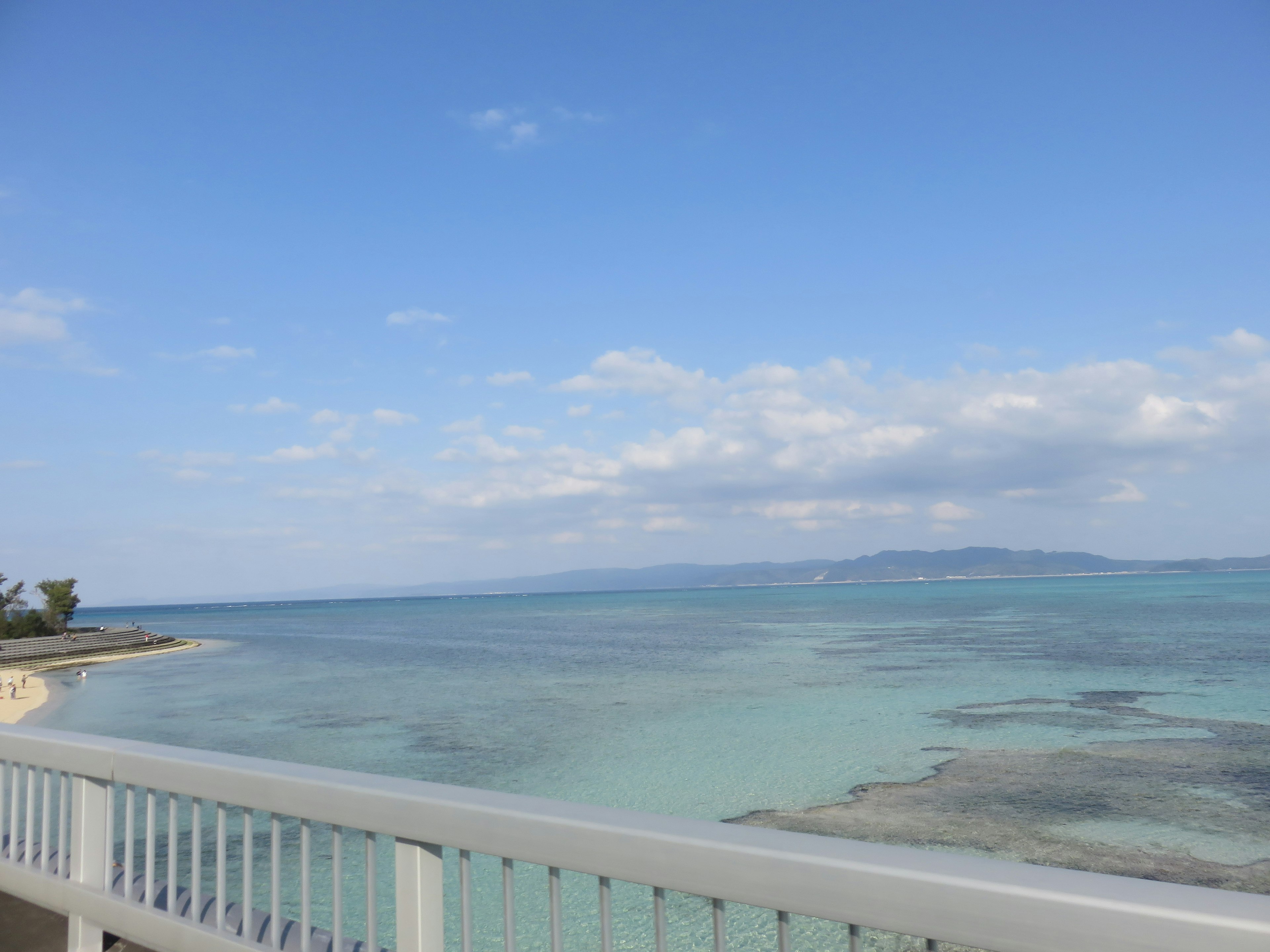 Malersicher Blick auf den blauen Ozean und den Himmel mit einem weißen Geländer