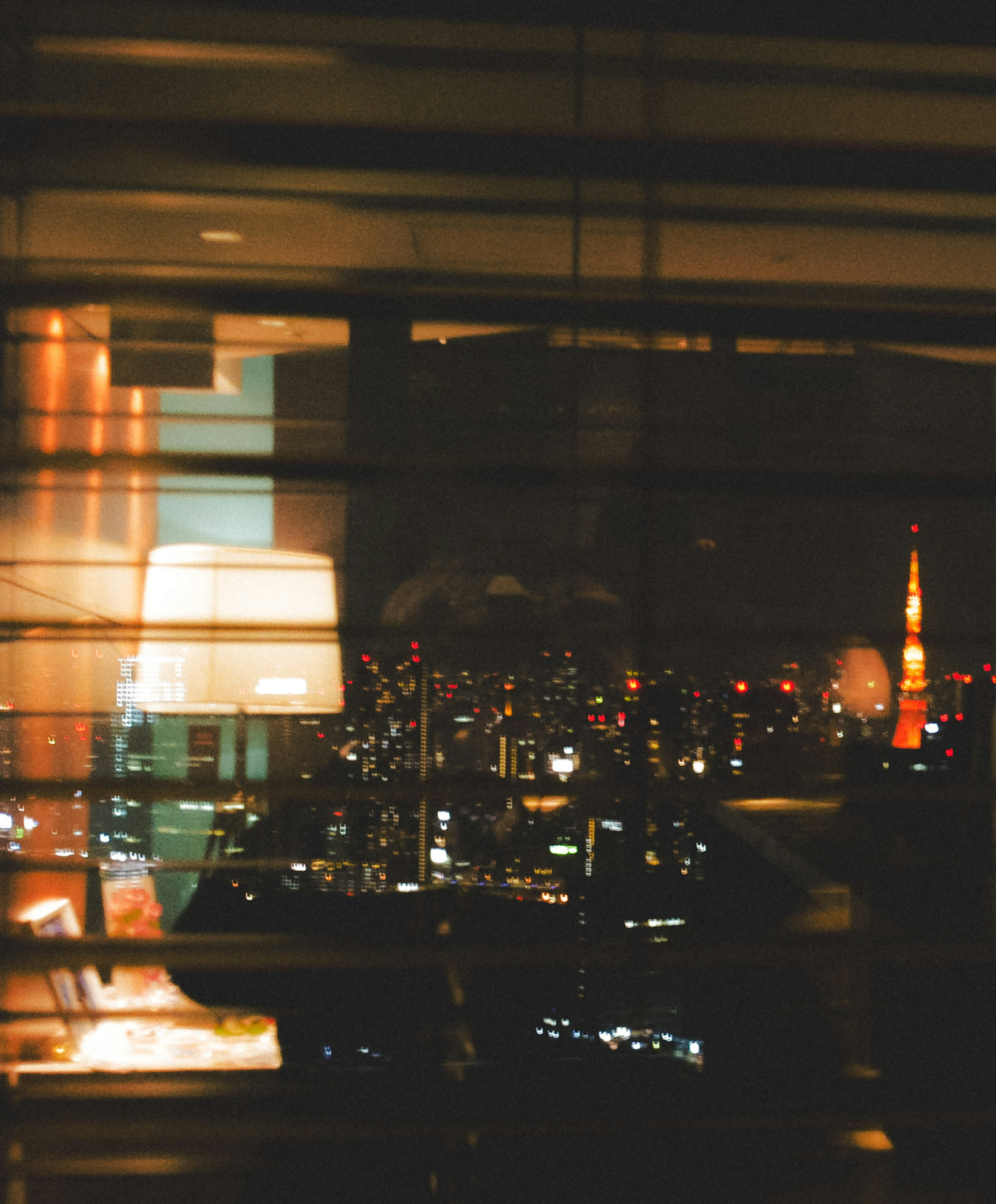 Nachtansicht des Tokyo Tower durch ein Fenster