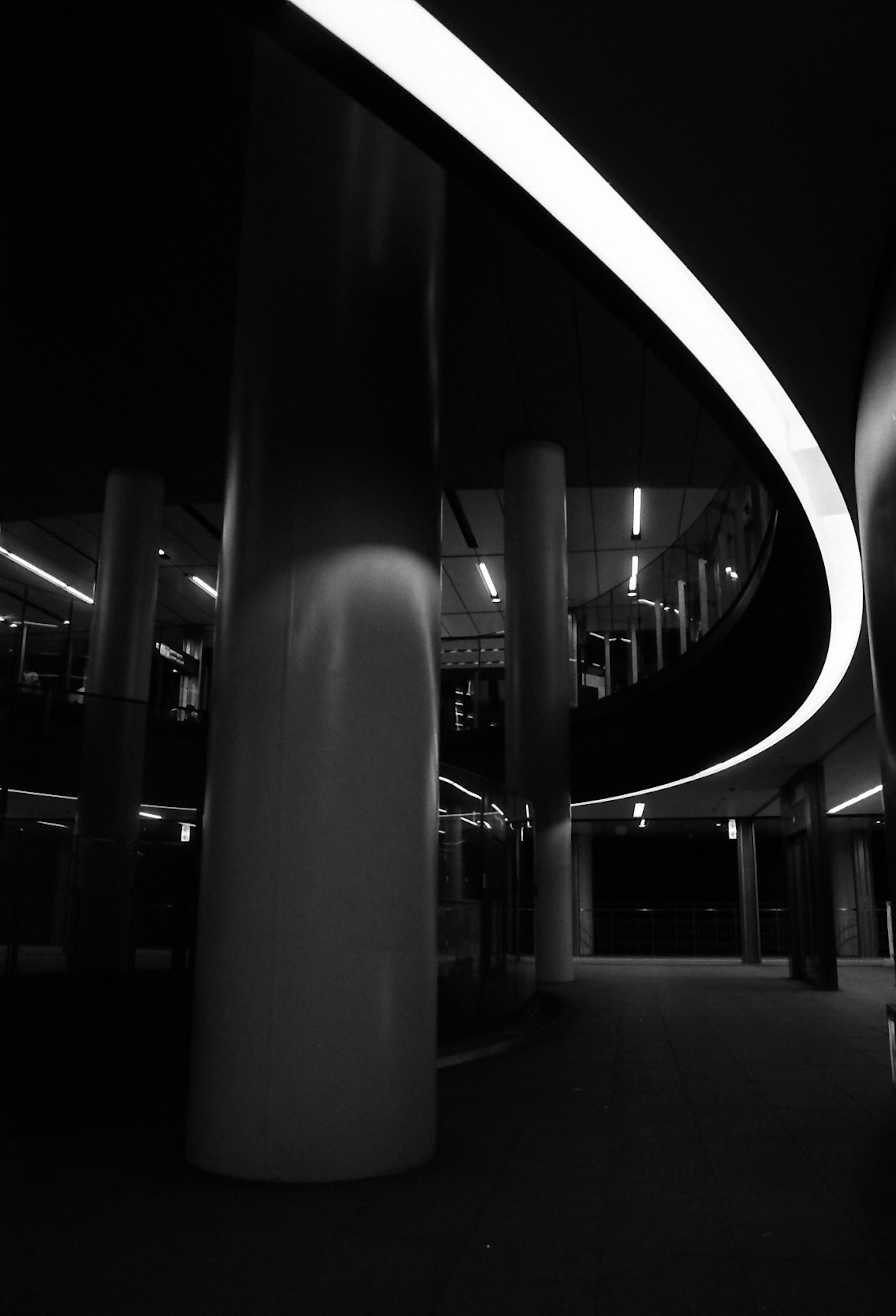 Interior of a modern building featuring curved white lighting and pillars