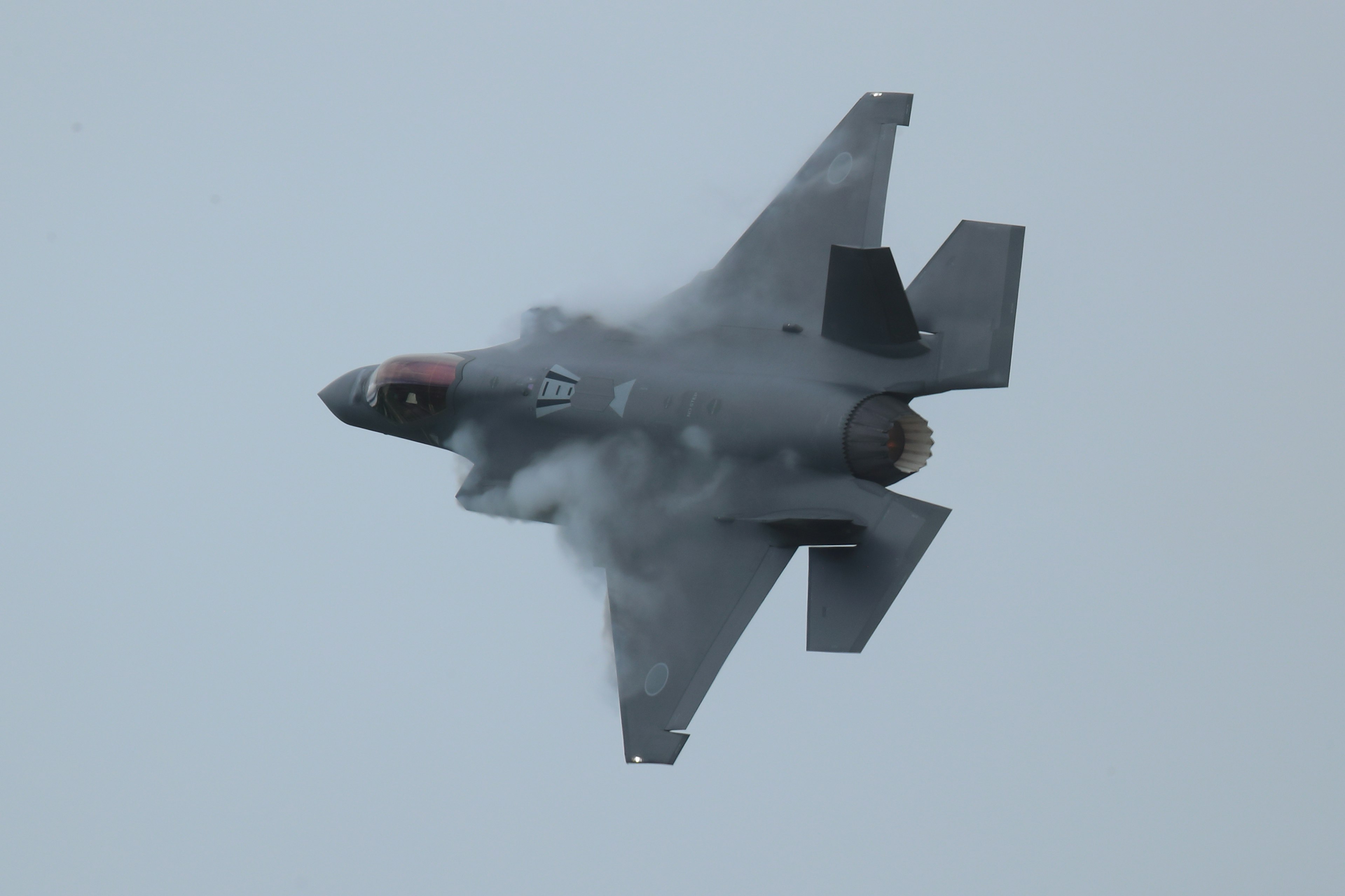 A fighter jet flying through clouds