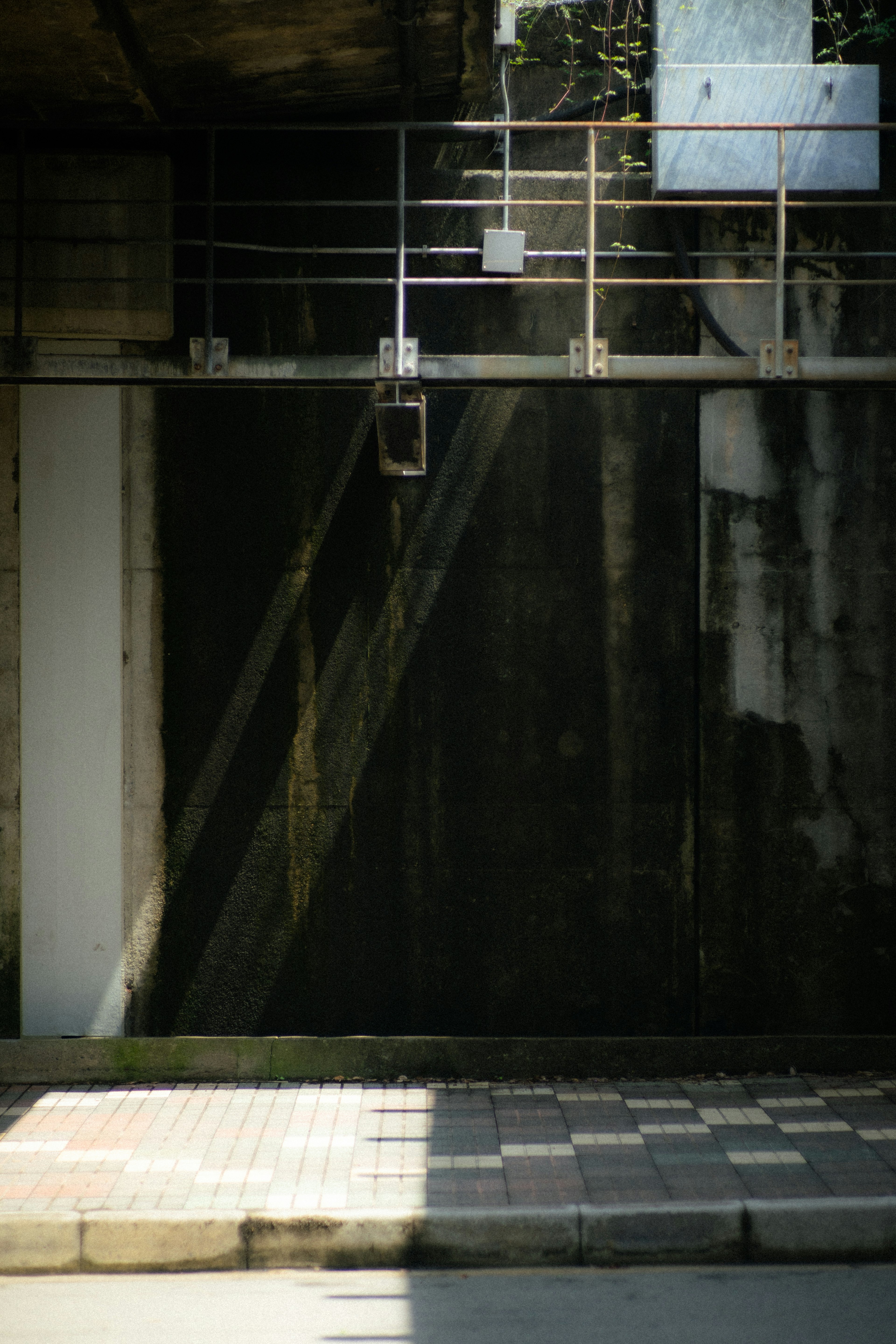 Urban scene highlighting the contrast of a black wall and shadows