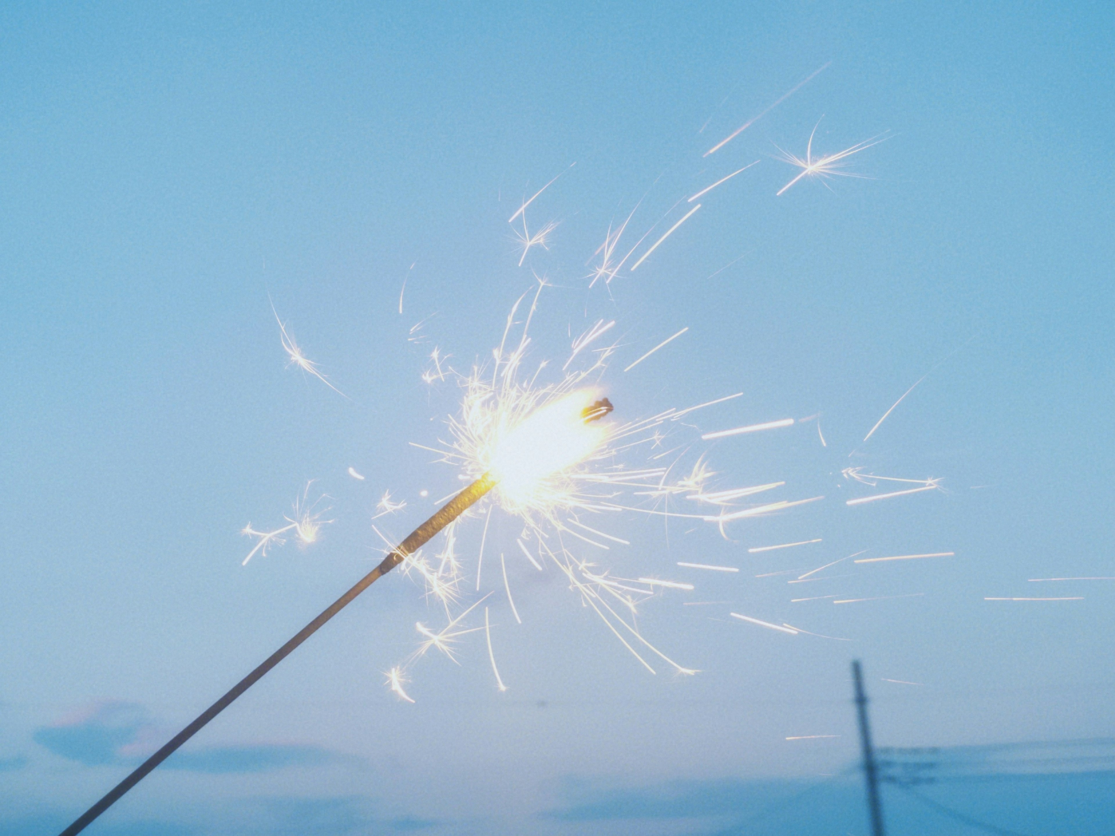 青空の下で輝く花火のスパークラー