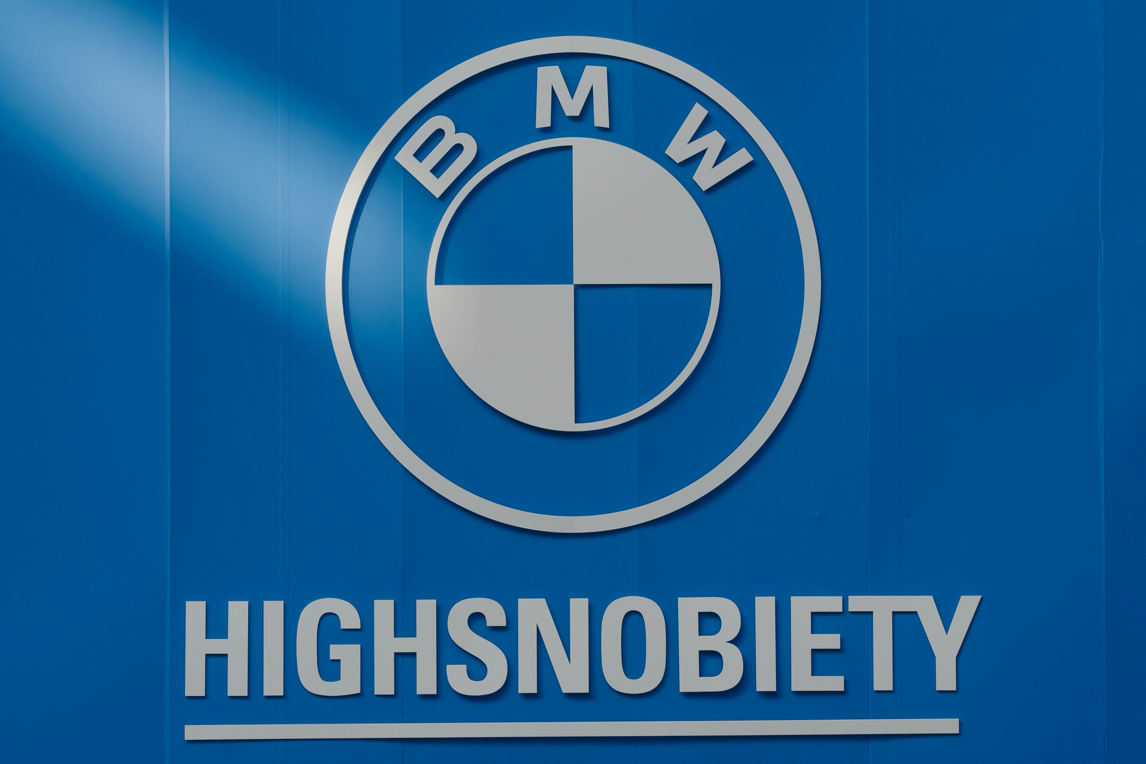 BMW-Logo mit dem Markennamen Highsnobiety auf blauem Hintergrund