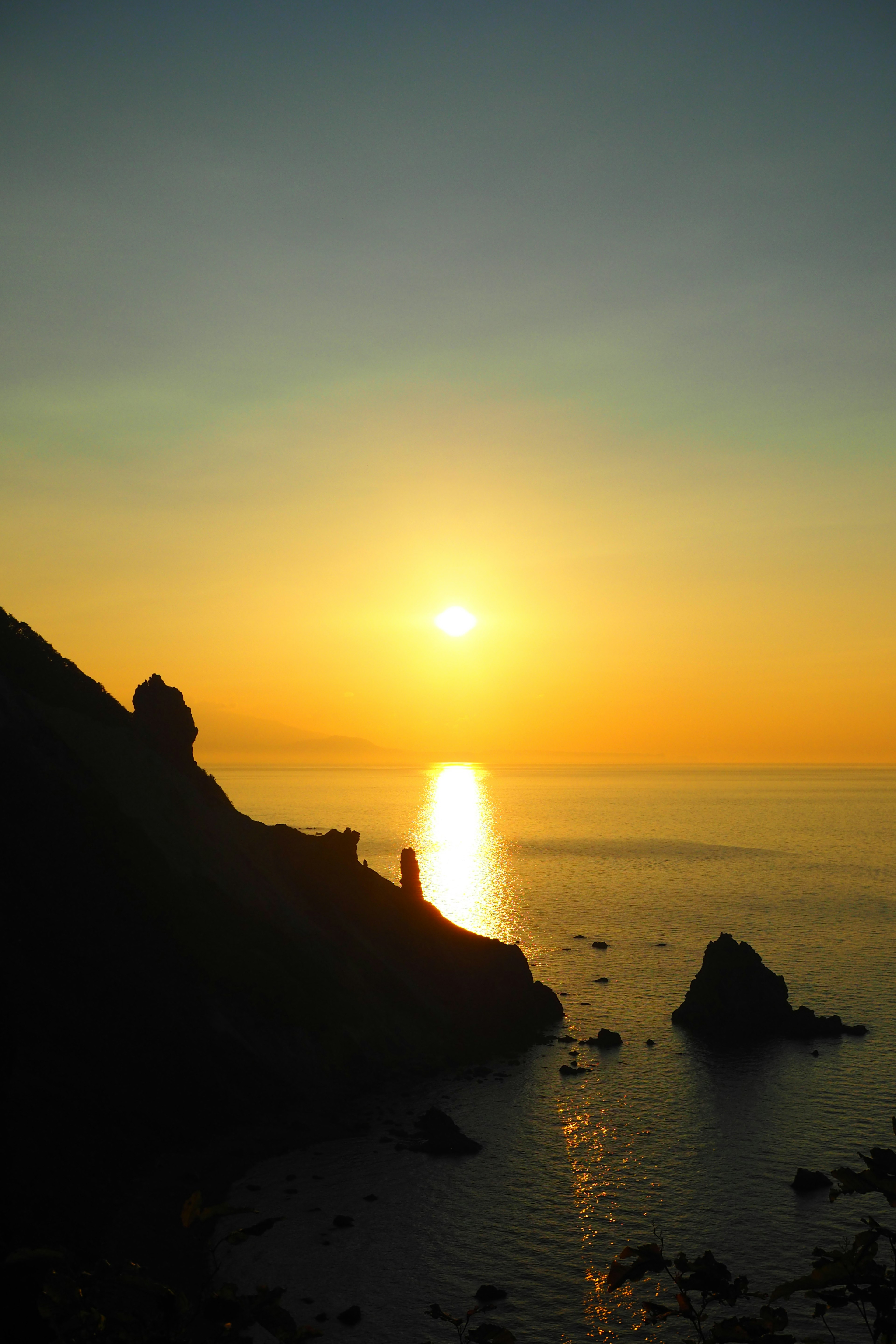 Paysage magnifique du coucher de soleil sur la mer avec des rochers en silhouette