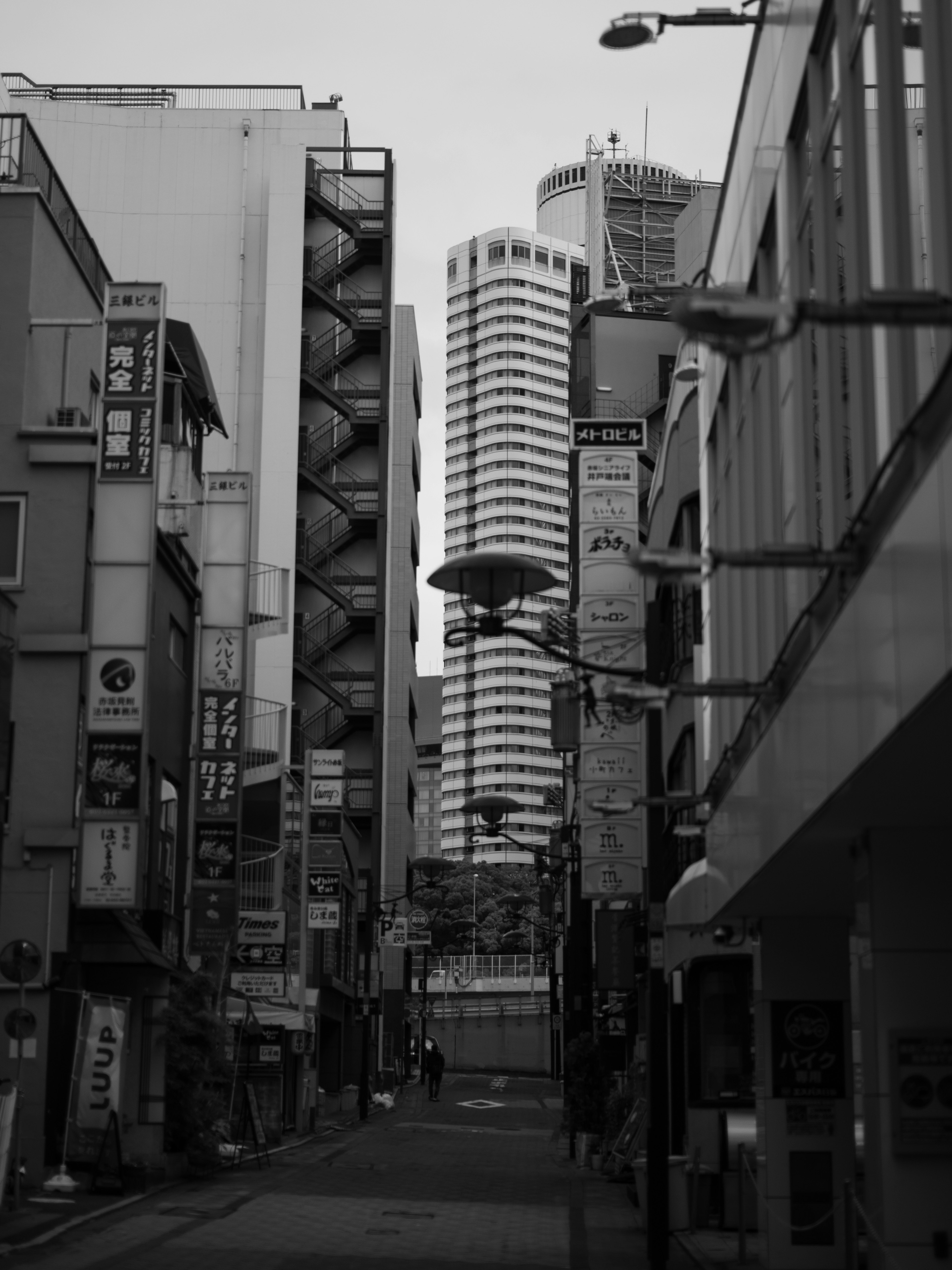 Black and white cityscape featuring tall buildings along a narrow street