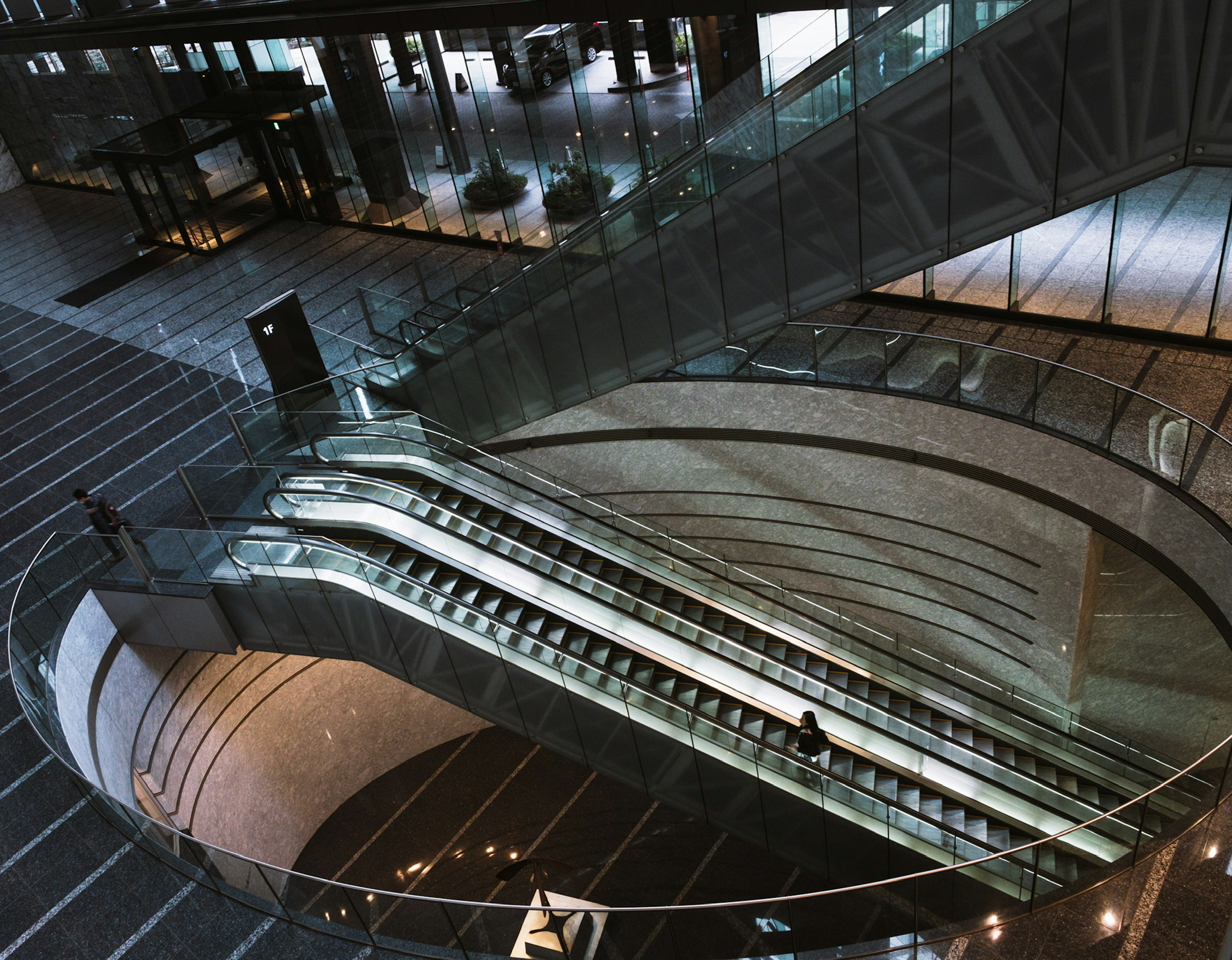 A bird's eye view of a circular escalator in a modern building interior