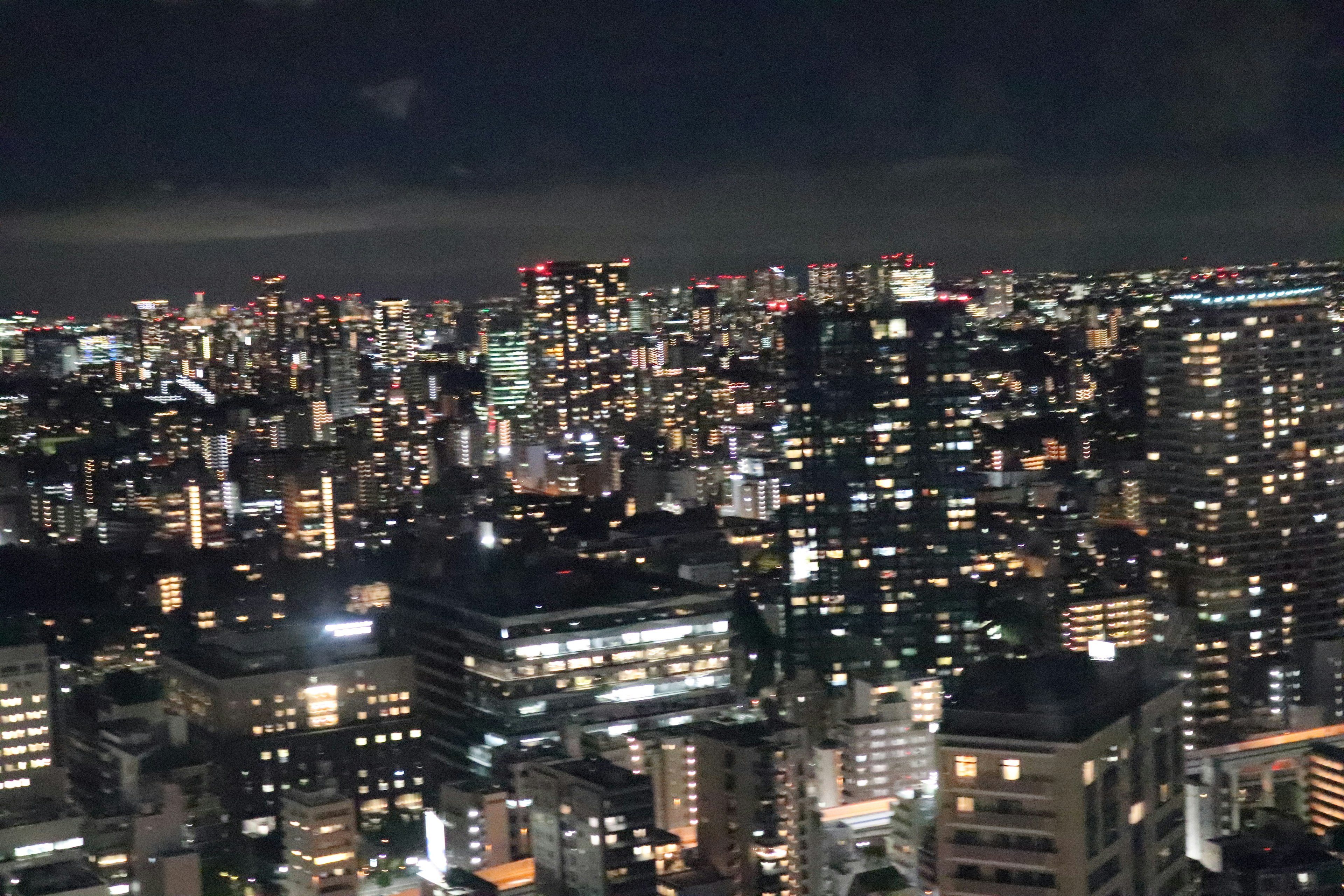 Pemandangan malam garis langit Tokyo dengan gedung pencakar langit yang diterangi