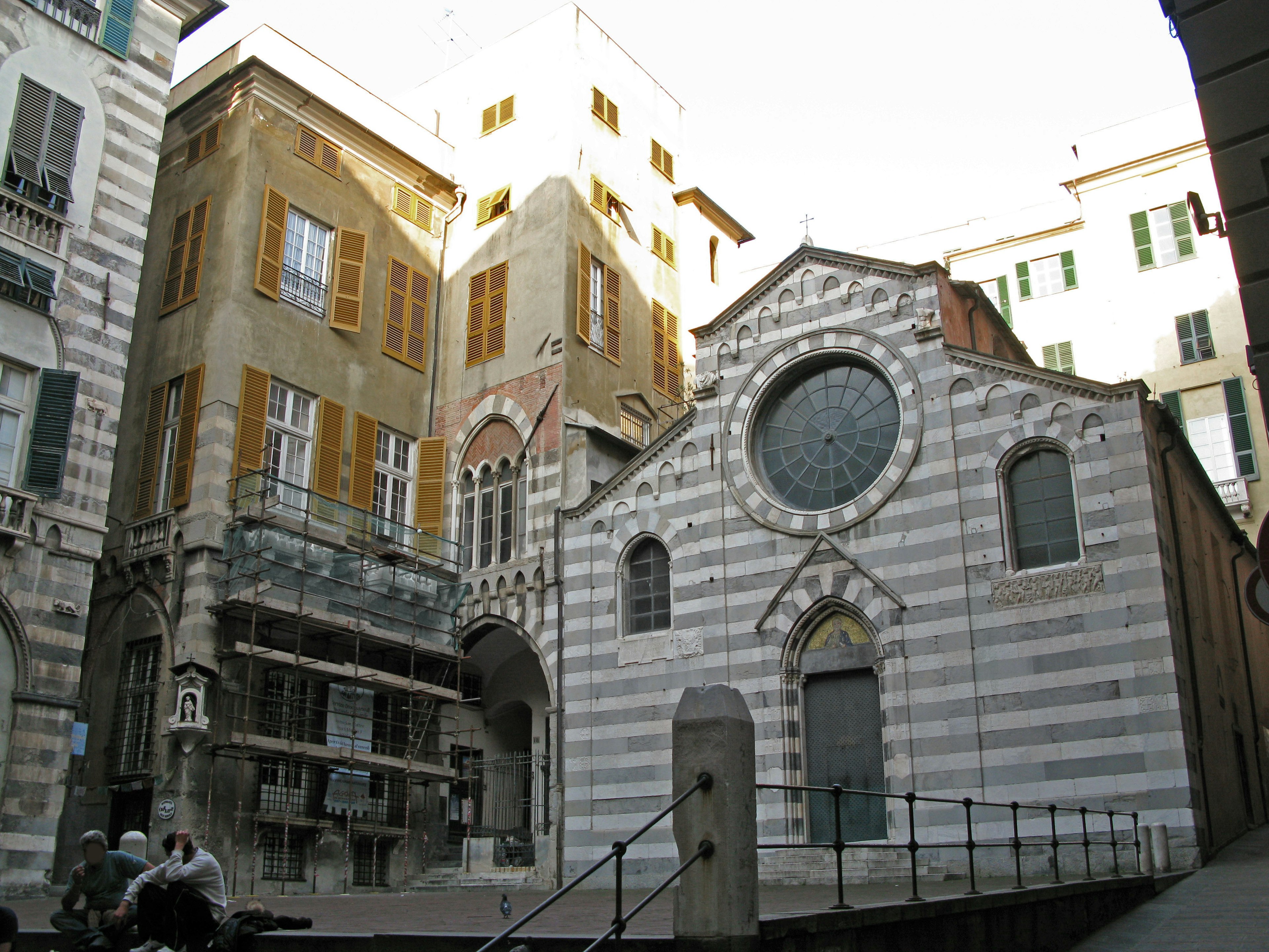 Gestreifte Kirche und historische Gebäude auf einem Platz in Genua