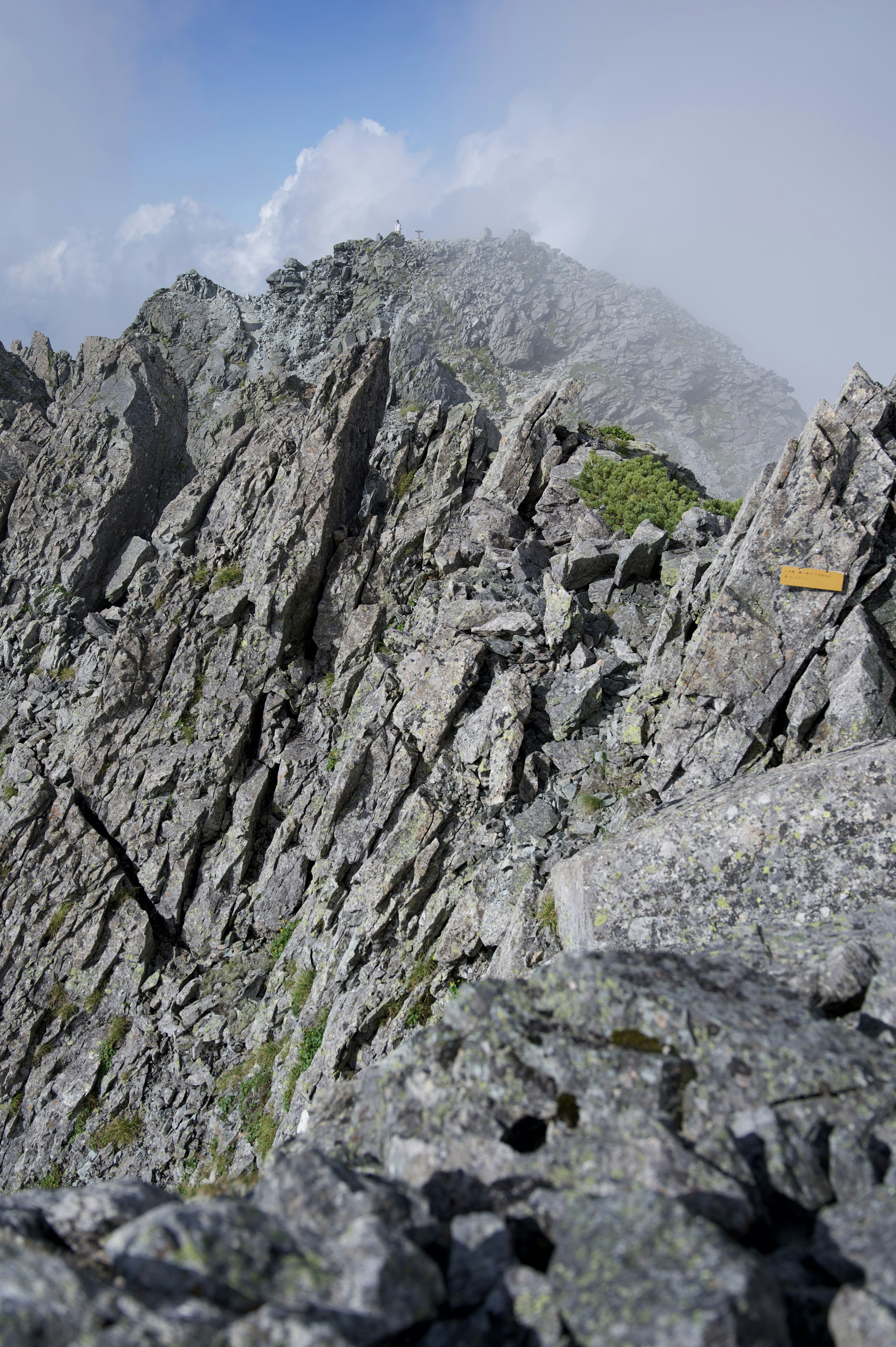 Terreno roccioso di montagna accidentato sotto un cielo blu nuvoloso