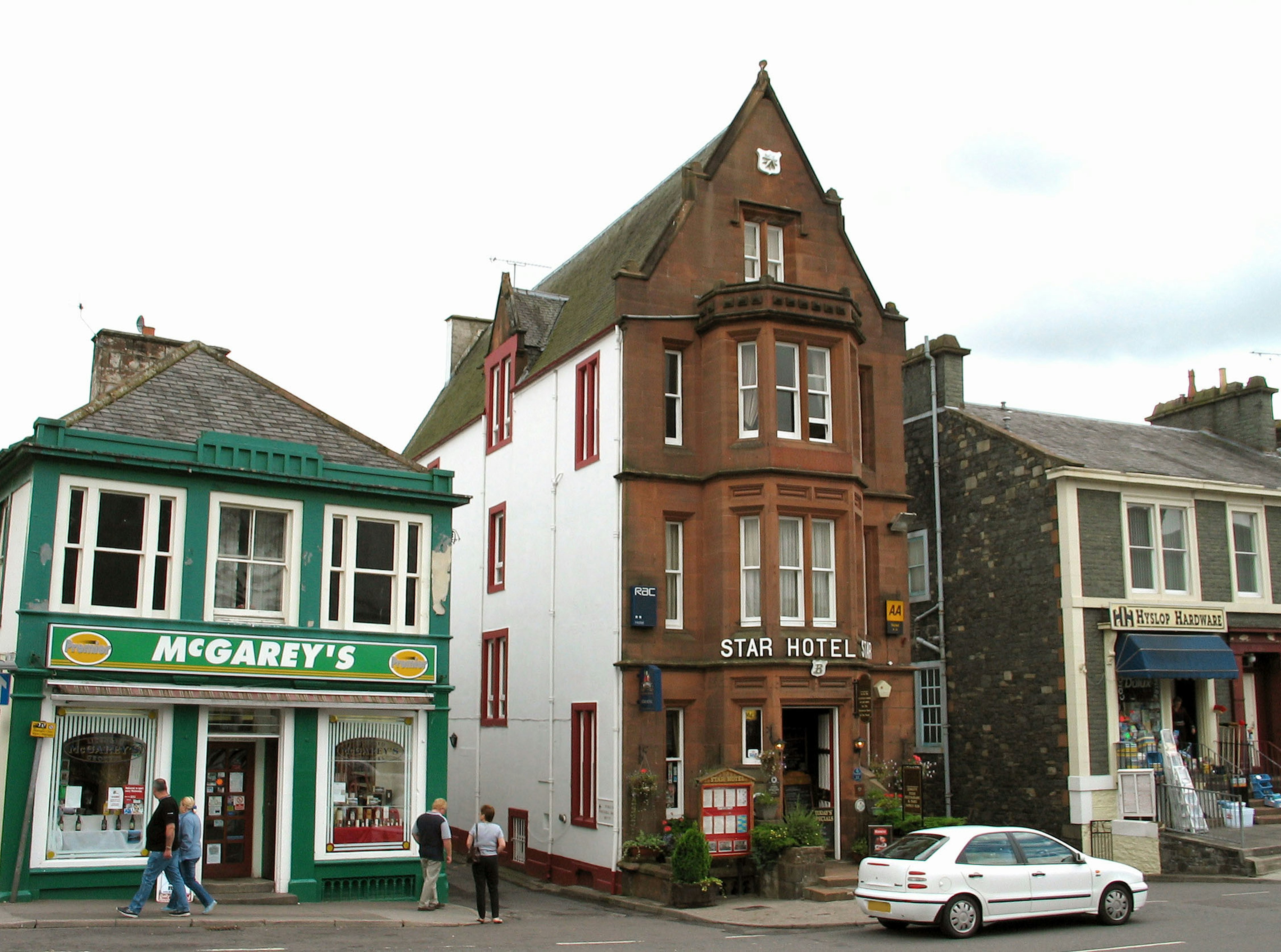 Vue de rue avec l'hôtel Star en rouge-brun et le magasin vert McGarry's